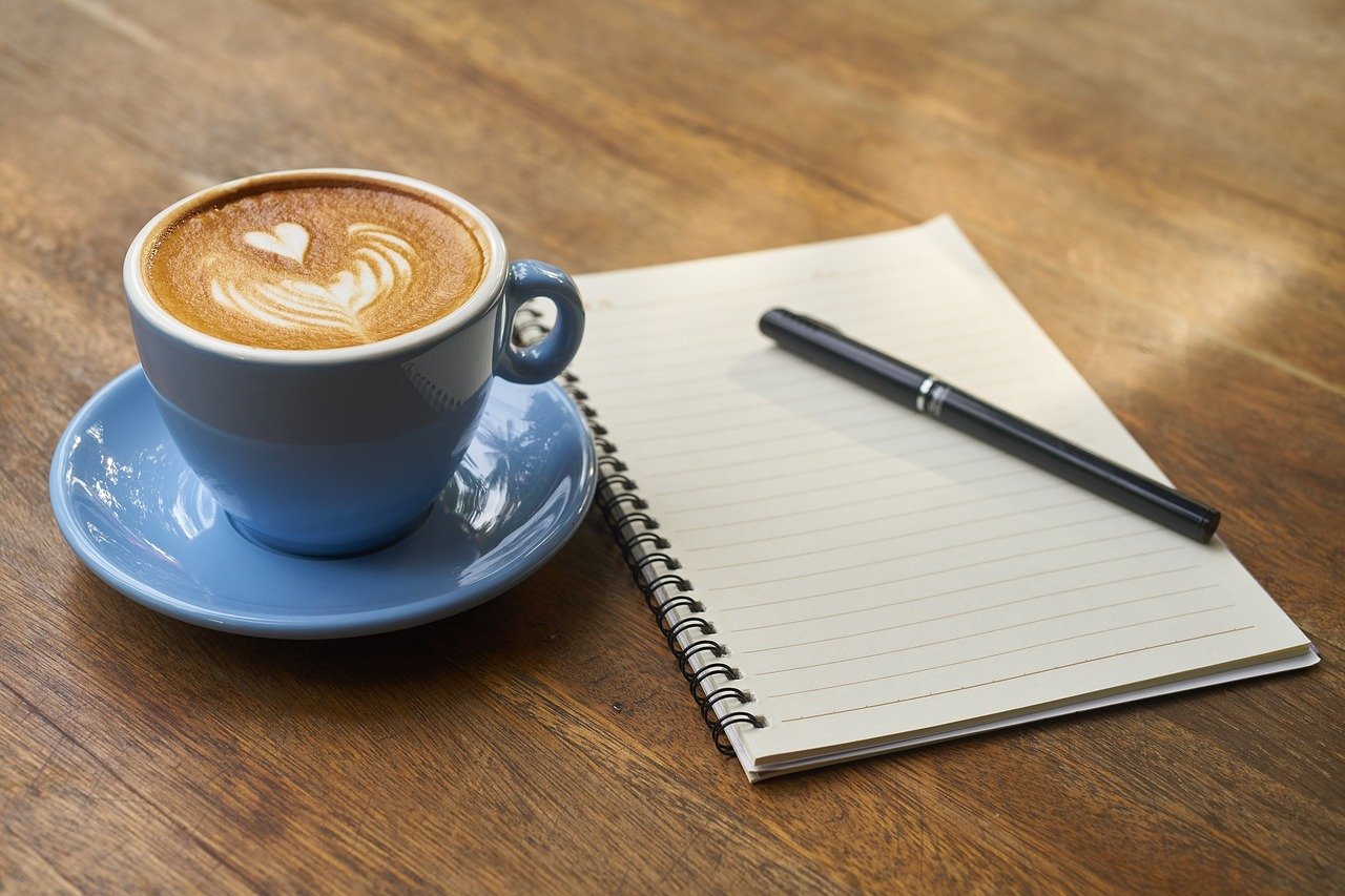 Latte and notepad at College Drive Cafe