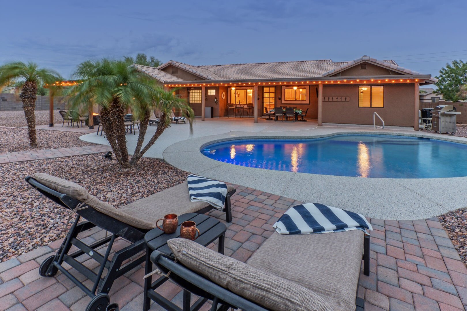 Pool and patio at dusk with string lights