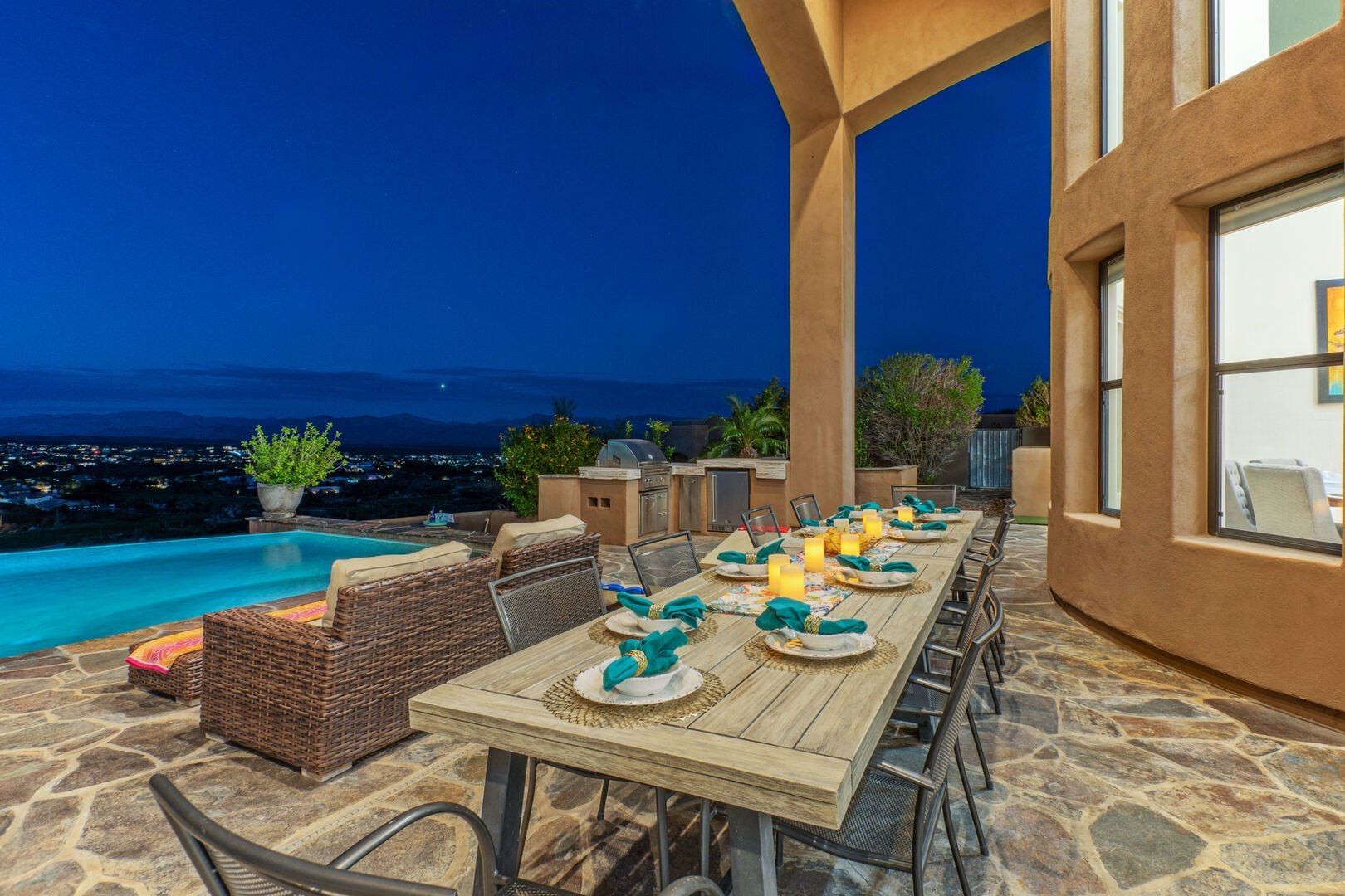 Outdoor dining patio with pool and city views at night