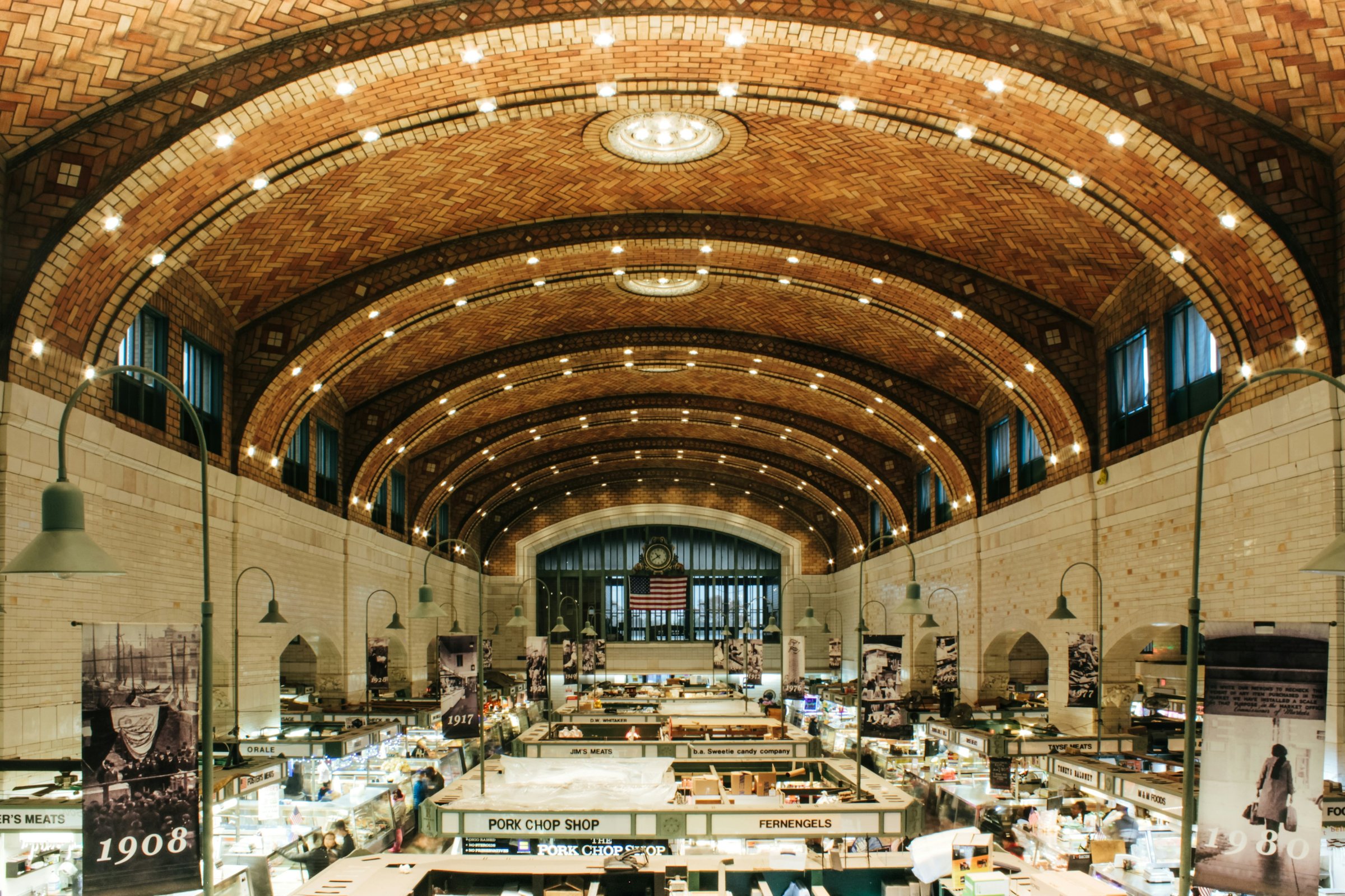 The West Side Market interior in Cleveland's Ohio City with produce and butcher stalls under the arched ceiling