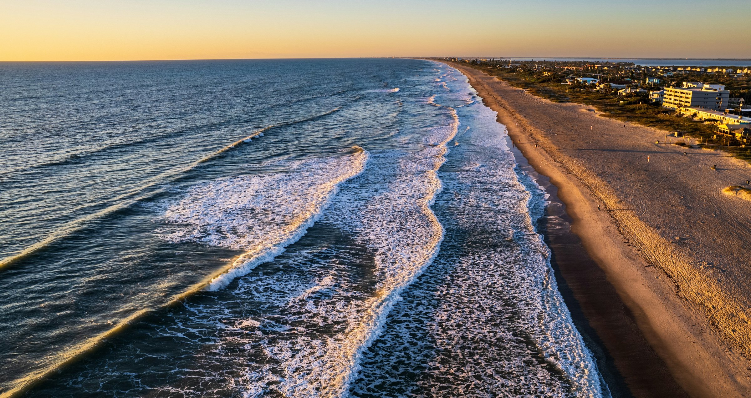 Atlantic shoreline at Cocoa Beach, Florida, with low morning surf and a wide flat stretch of sand