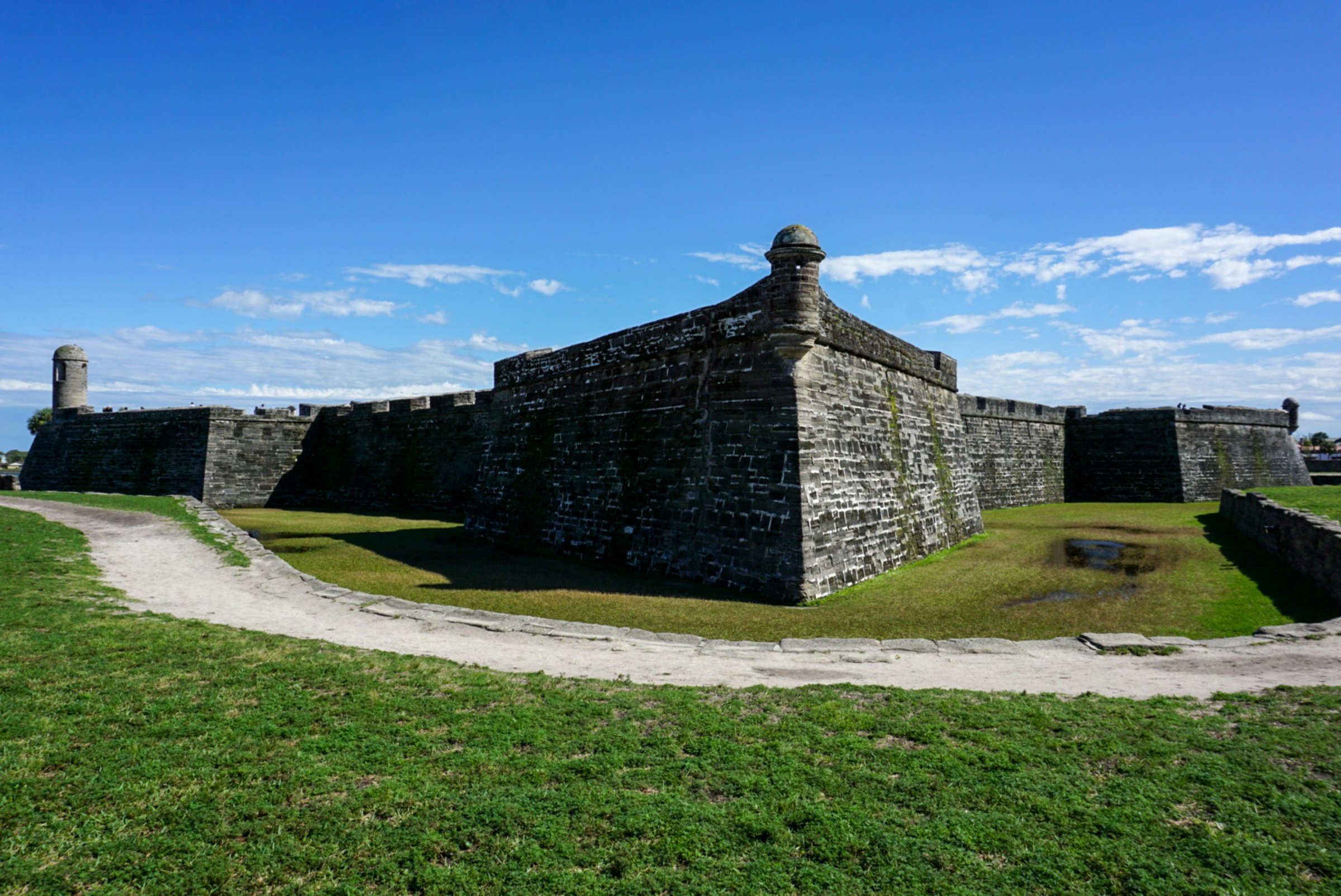 The coquina stone walls and seawall walkway at Castillo de San Marcos in downtown St. Augustine on a clear morning