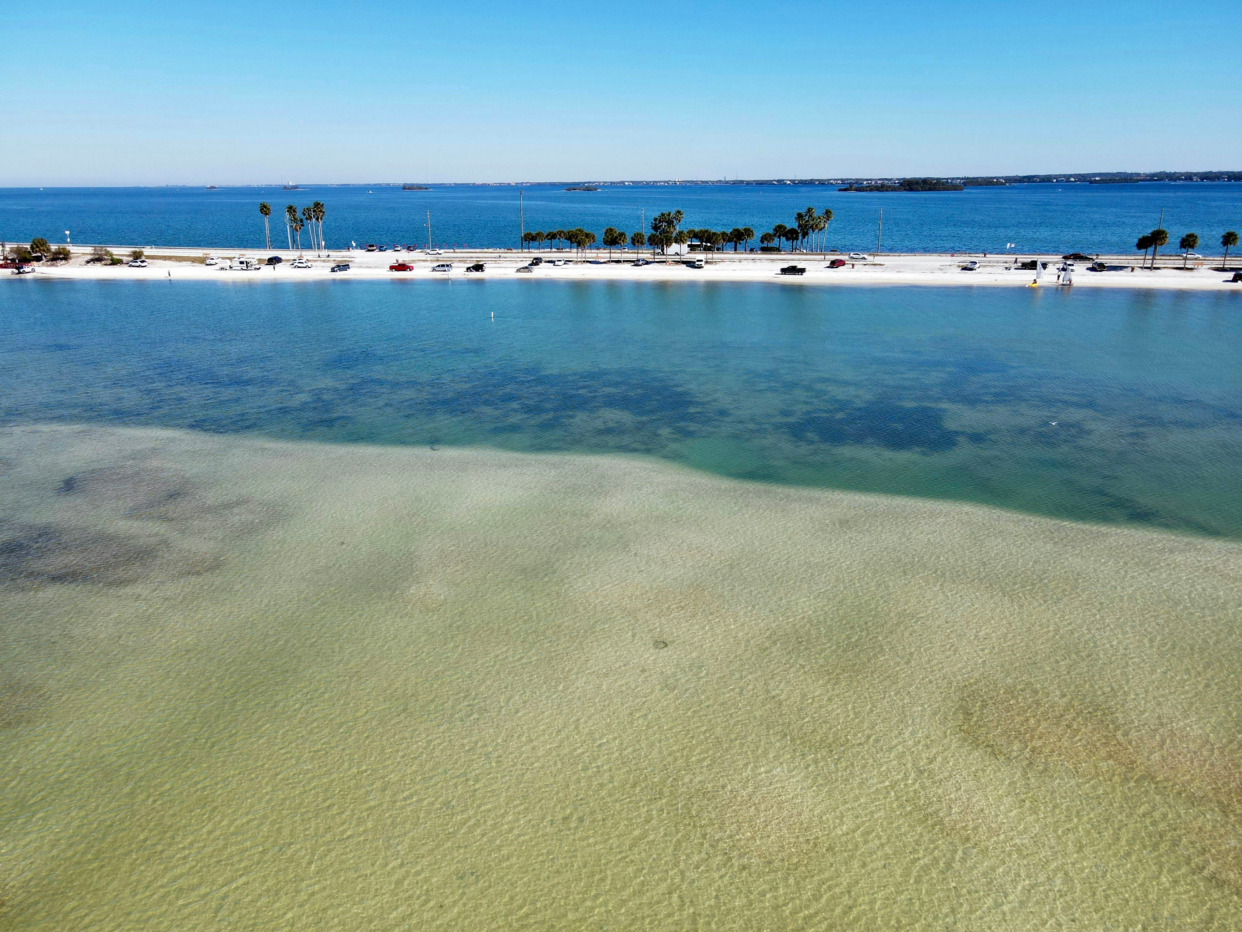 Aerial view of white sand beach and blue-green Gulf water near Holmes Beach, Florida