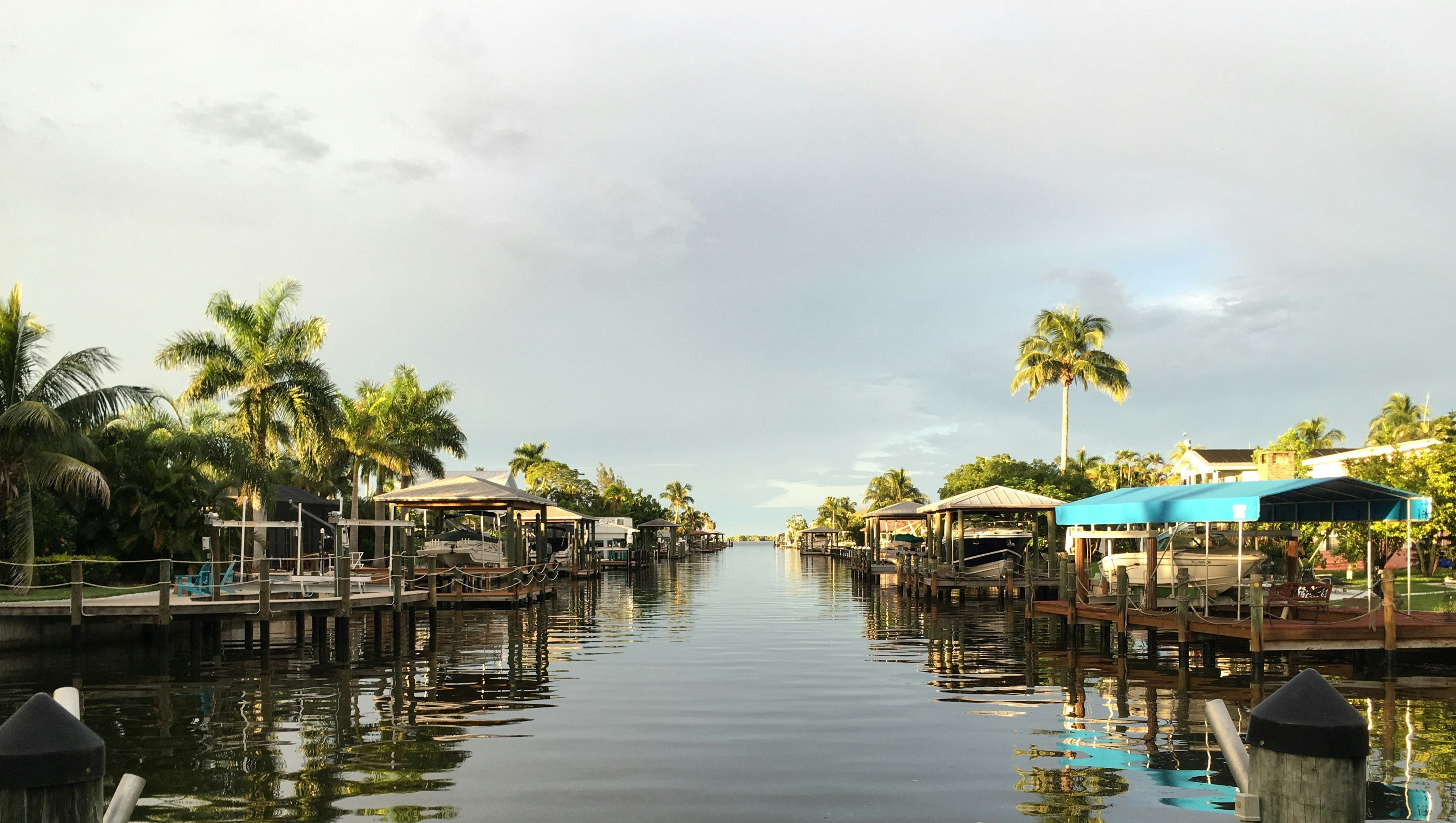 Florida waterfront canal with vacation rental homes, docks, and palm trees in Bradenton area
