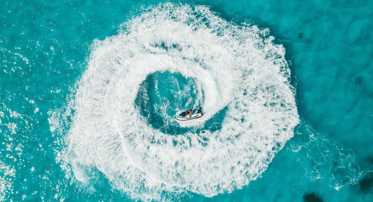Aerial view of jet ski water sports activity in turquoise waters off Seven Mile Beach Grand Cayman showing crystal-clear Caribbean Sea conditions