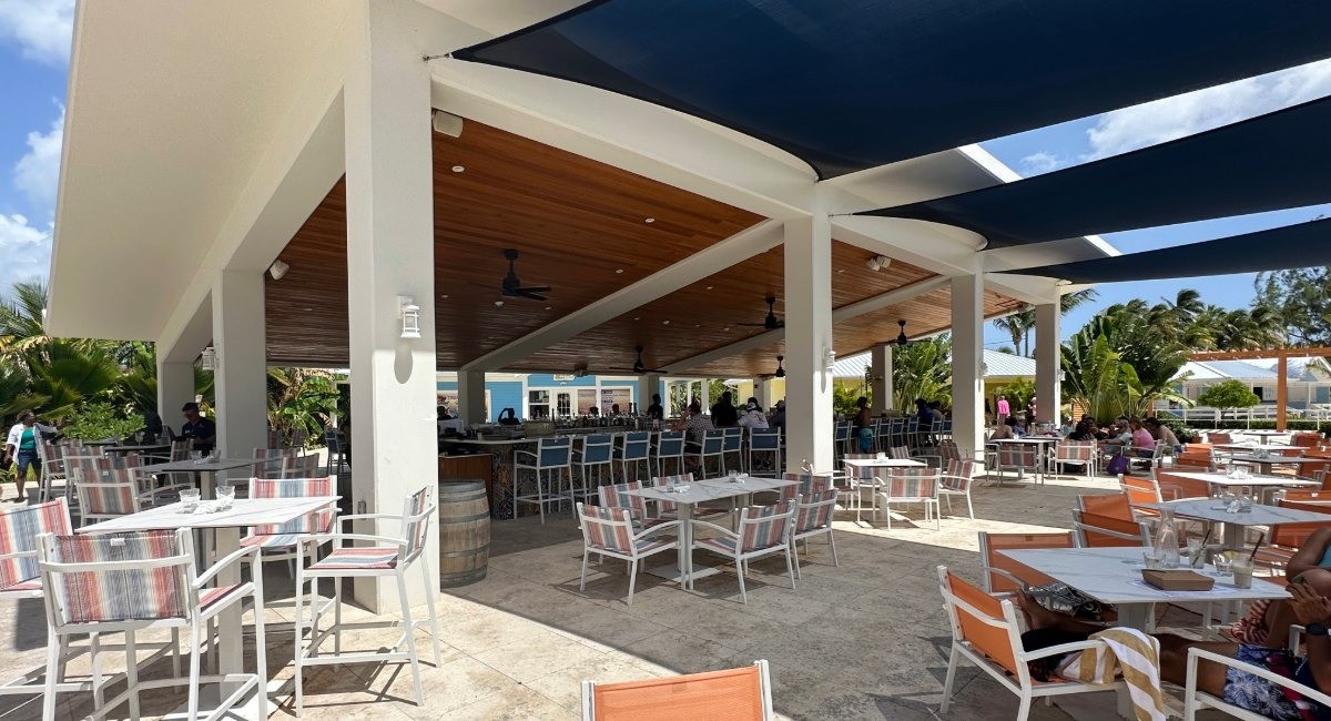 Solis restaurant at Rum Point Club Grand Cayman featuring covered outdoor dining patio with modern furniture and ocean views for Caribbean Mediterranean cuisine