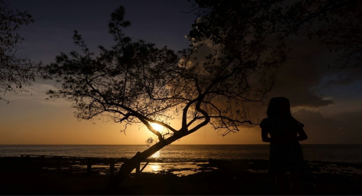 Silhouette of a person watching the sunset over the Caribbean Sea in the Cayman Islands