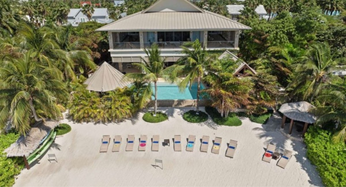 Private luxury home on Grand Cayman's beachfront with pool, palm trees and sun loungers