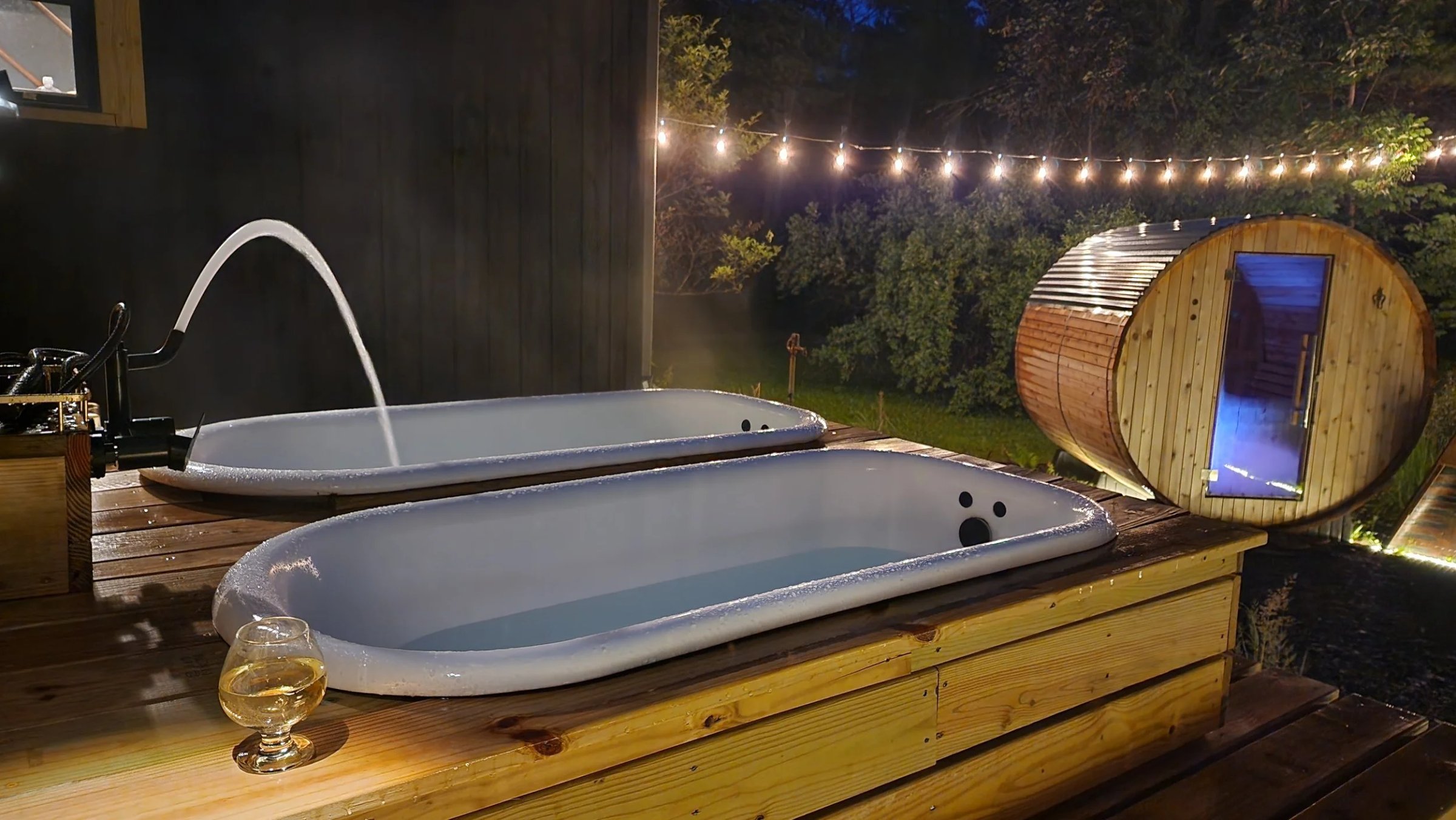 Tubs fillig up with Barrel Sauna and Glass of WIne at Night.jpg