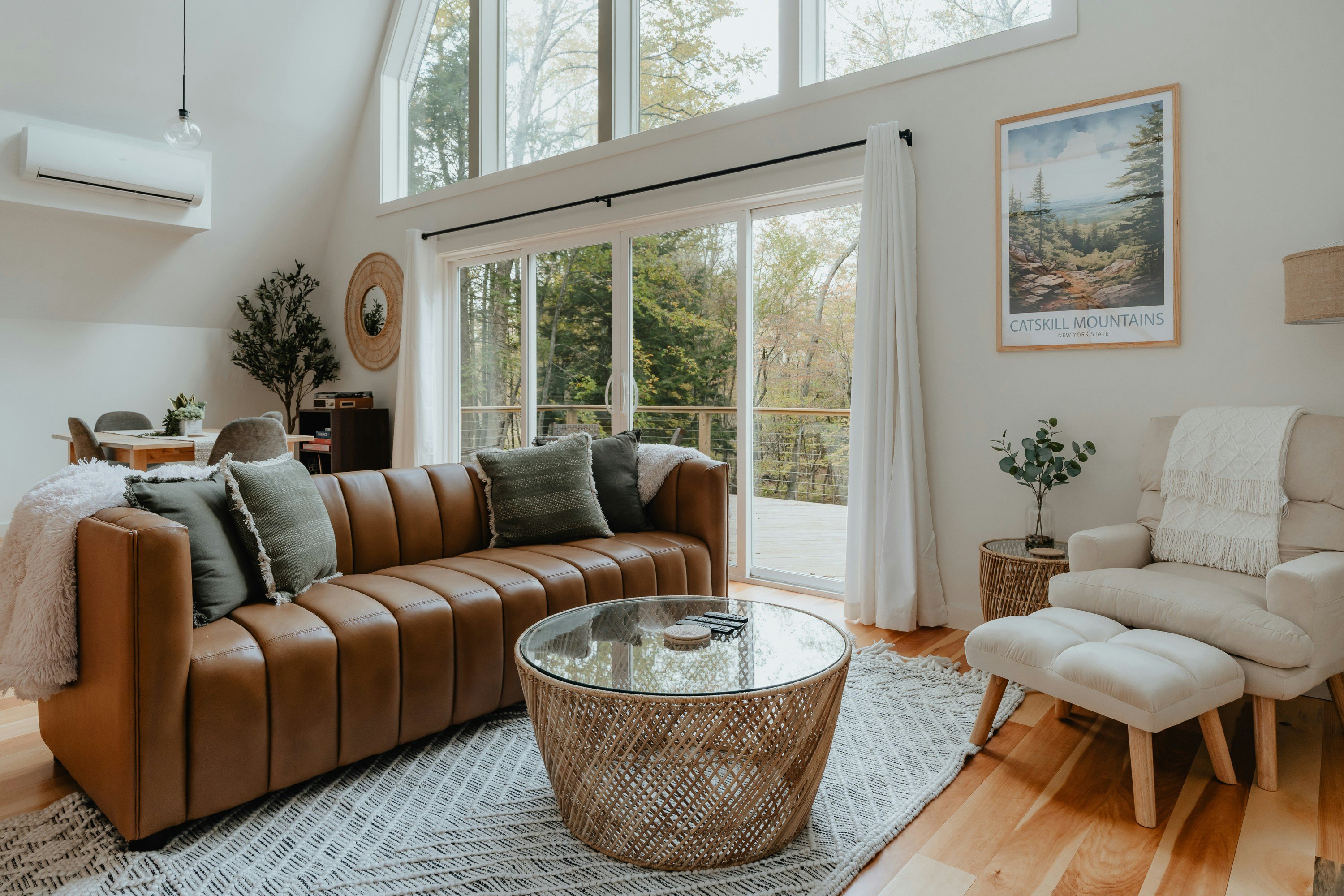 Furnished vacation rental living room with leather sofa and large windows