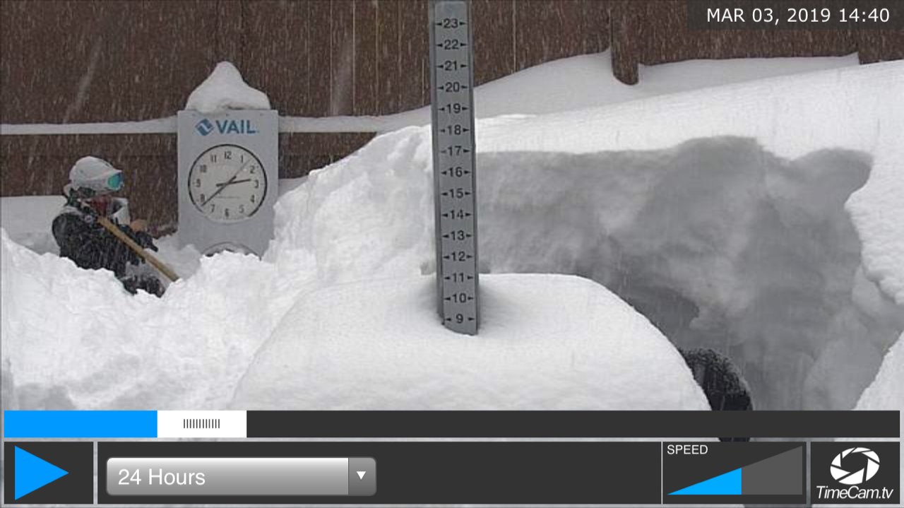 Vail employee shoveling snow from snowstake area