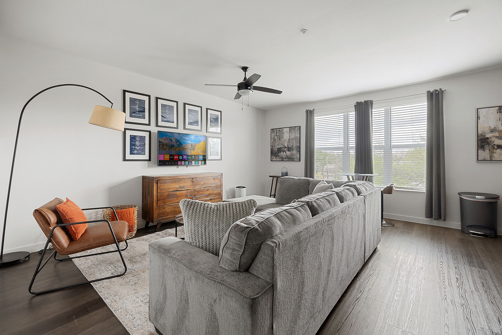 A modern, pet-friendly living room at PBD Living featuring a large sofa and bright windows