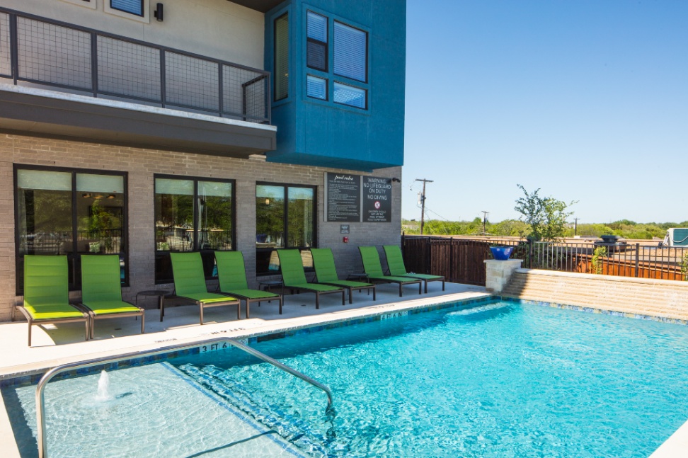 The outdoor pool area at a PBD Living property, offering a serene space for residents to unwind in the Dallas sun.