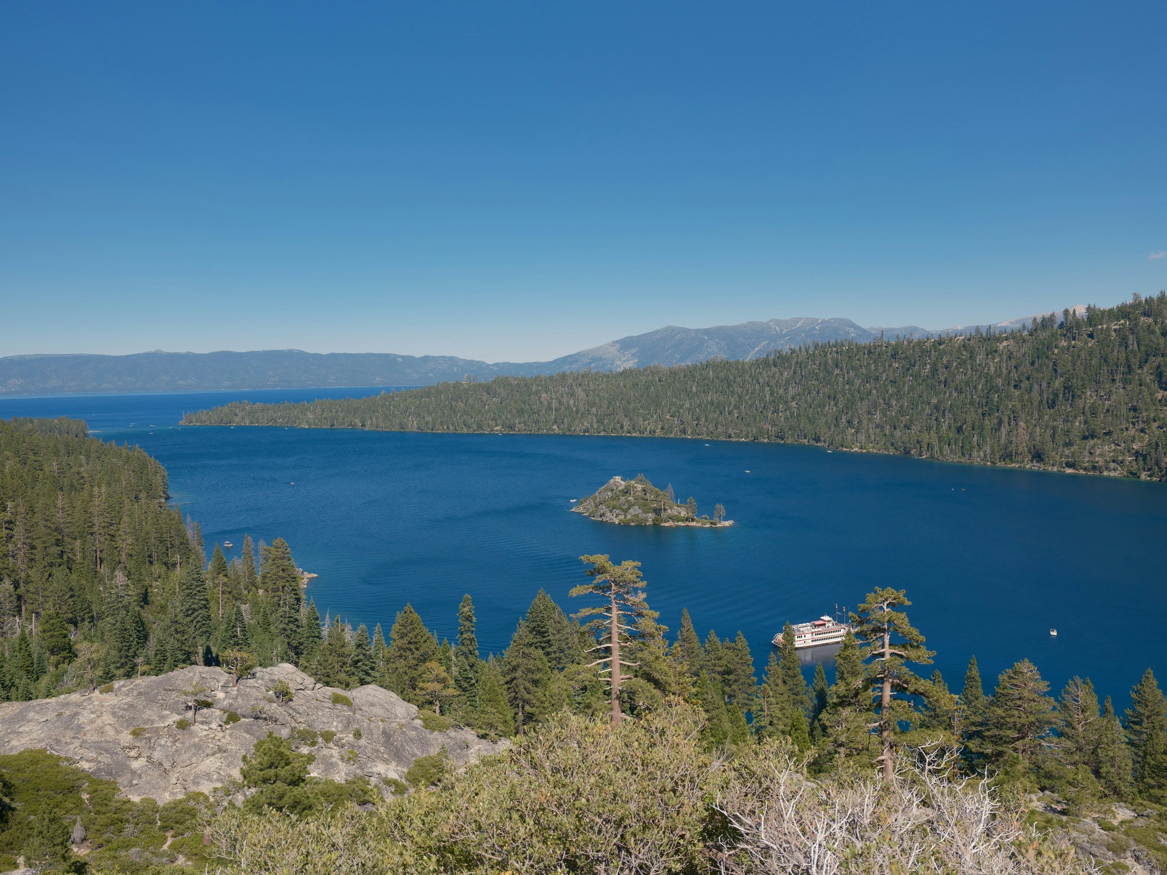 Emerald Bay seen from the Highway 89 overlook in summer, with Fannette Island in the middle of the bay and pine-covered slopes on both sides