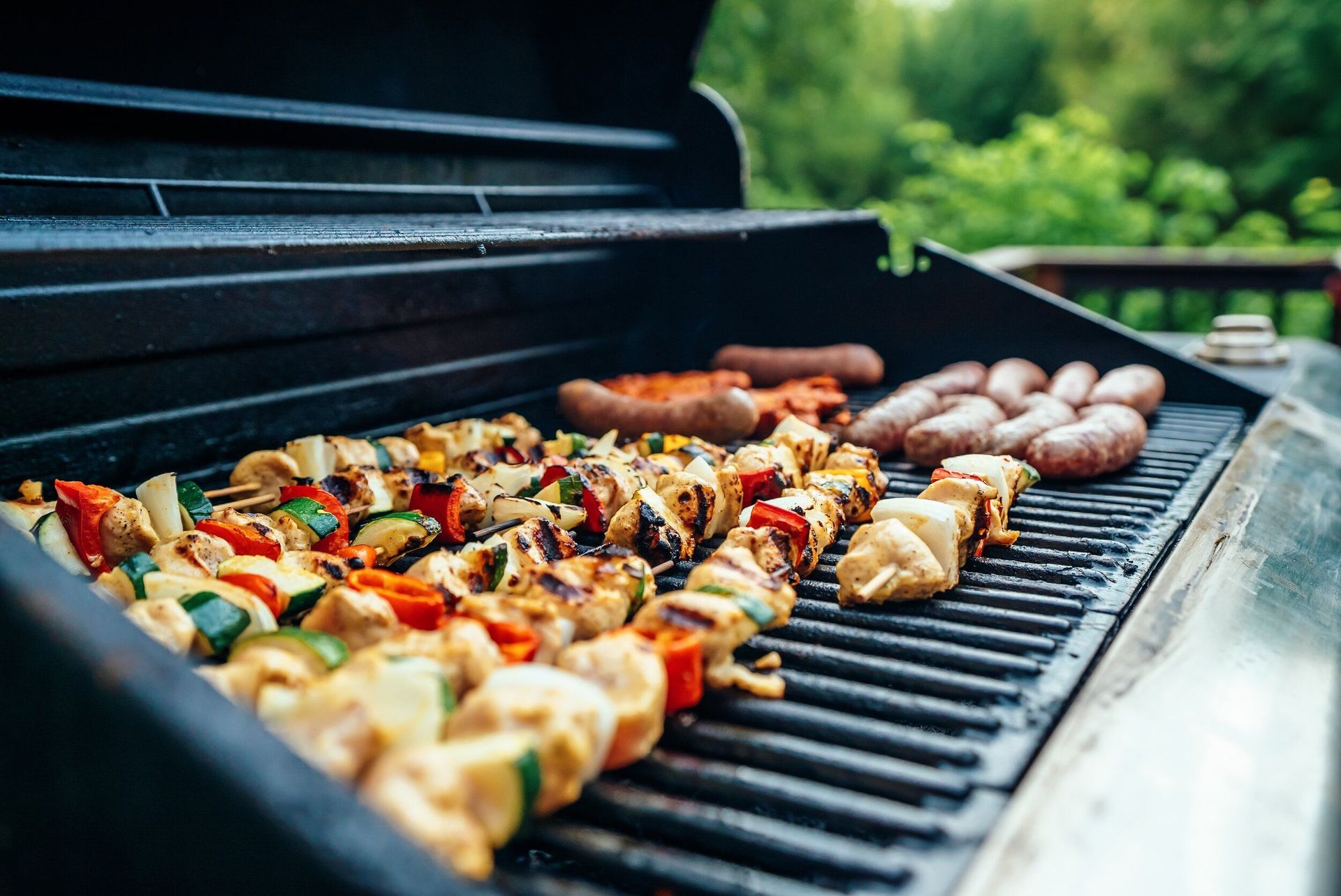 A grill filled with lots of meat and vegetables.