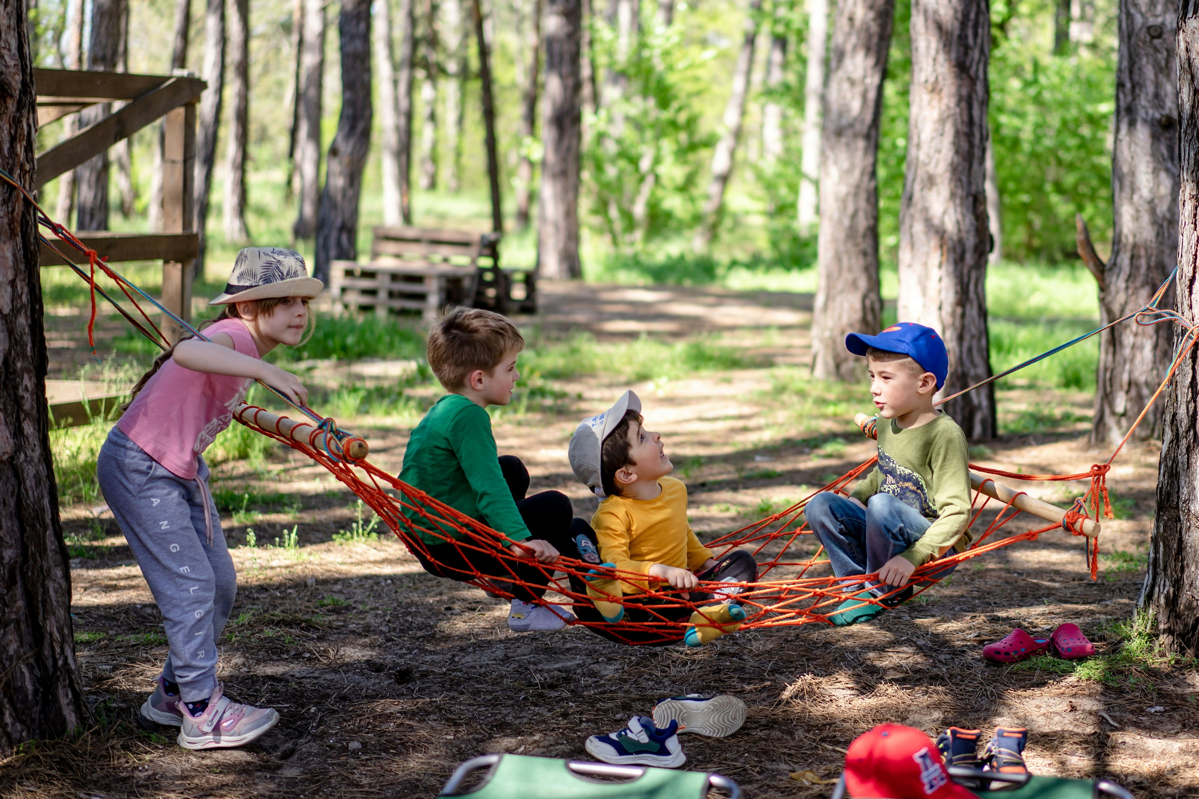 Kids playing in a hammock in the woods