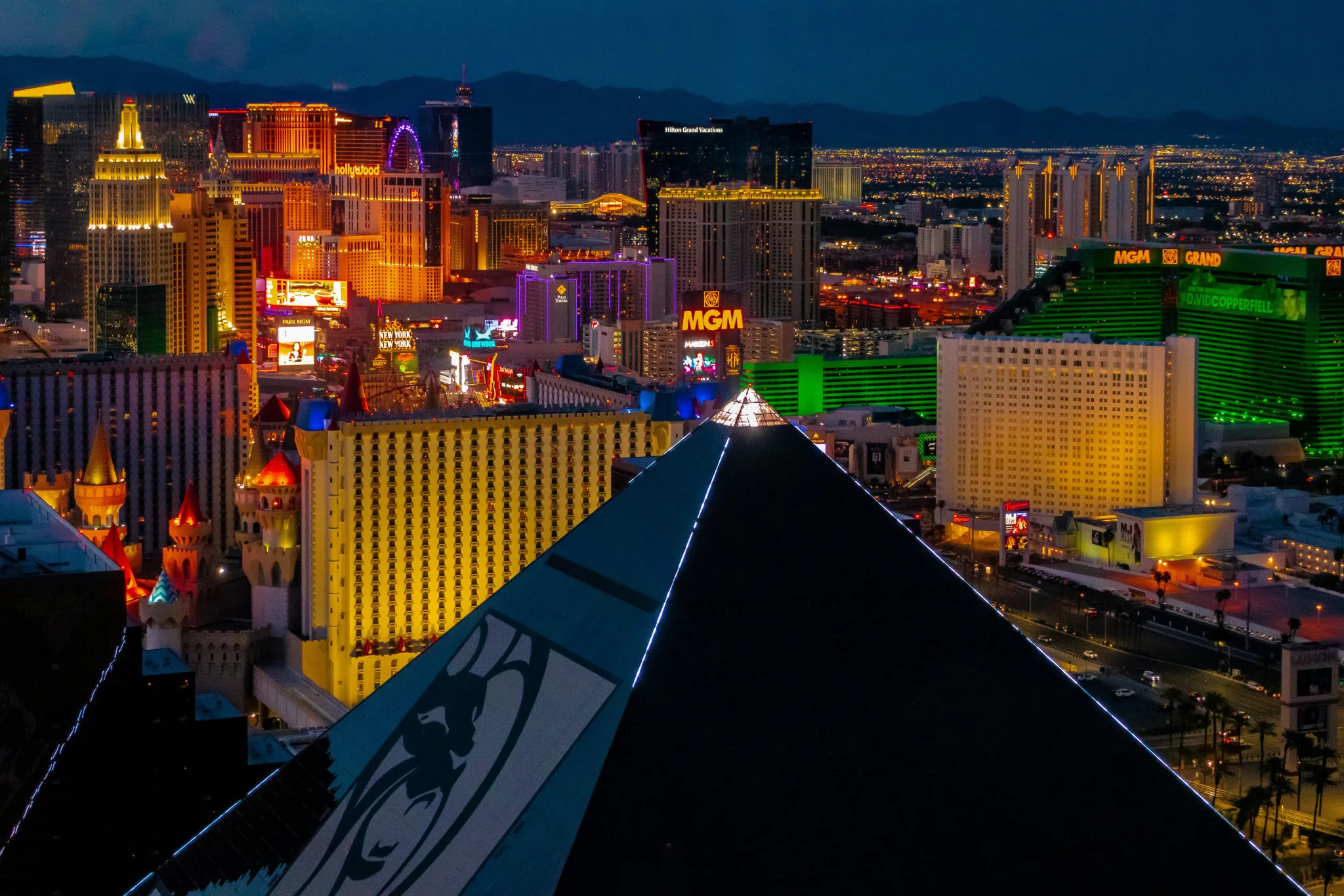 Vegas skyline from a rooftop, showing shadows of roofs and neon lights from the Strip