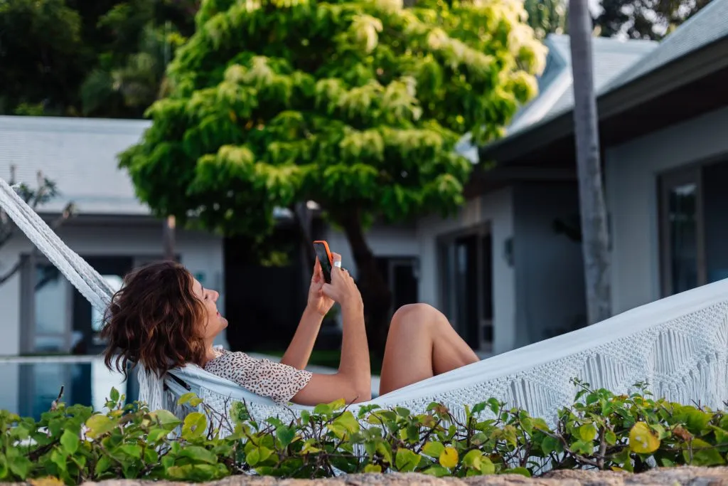 woman enjoying in a hammock in the yard of her eco friendly vacation rental