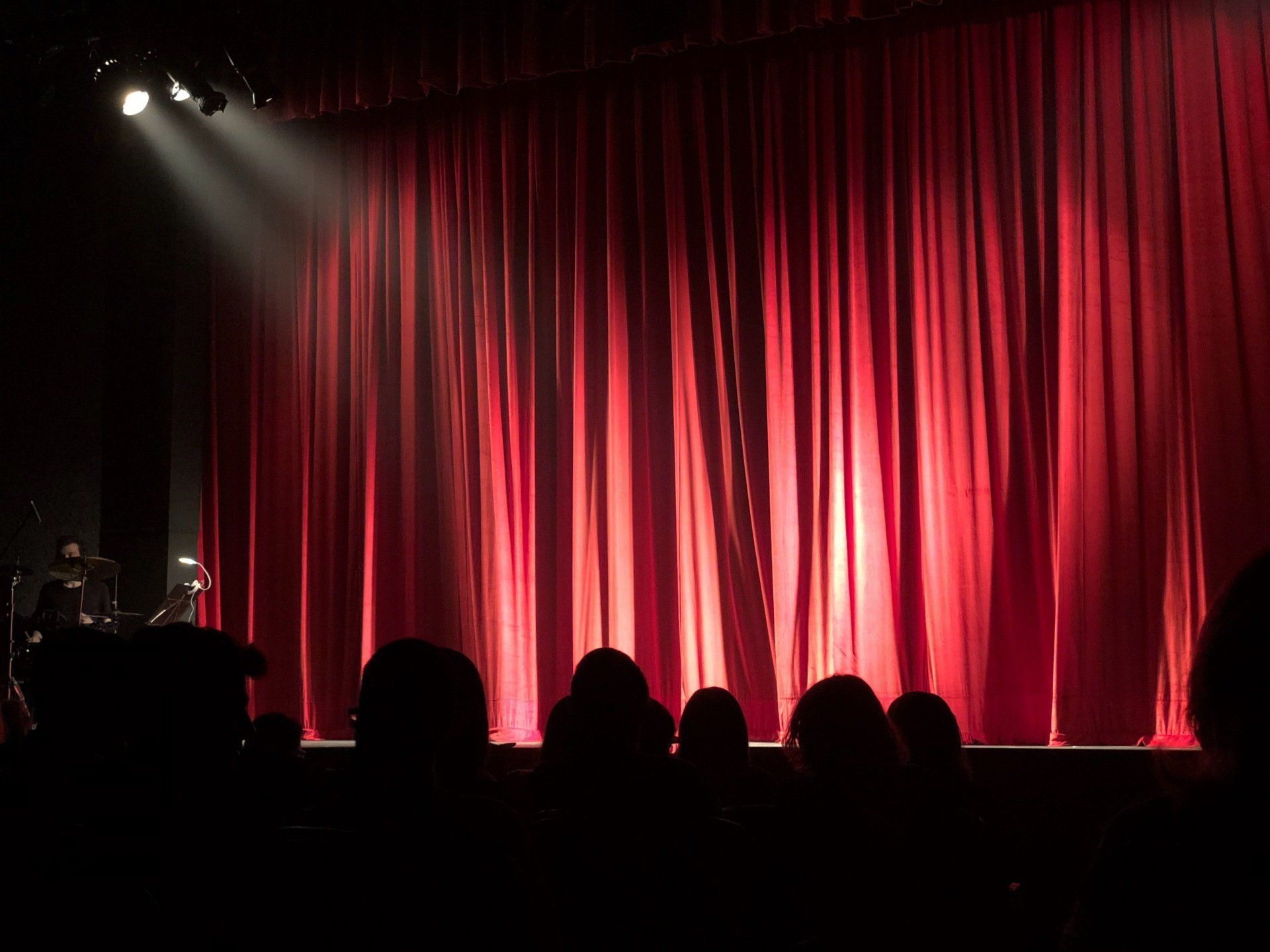 A photo of a theatre, with red backdrop drapes