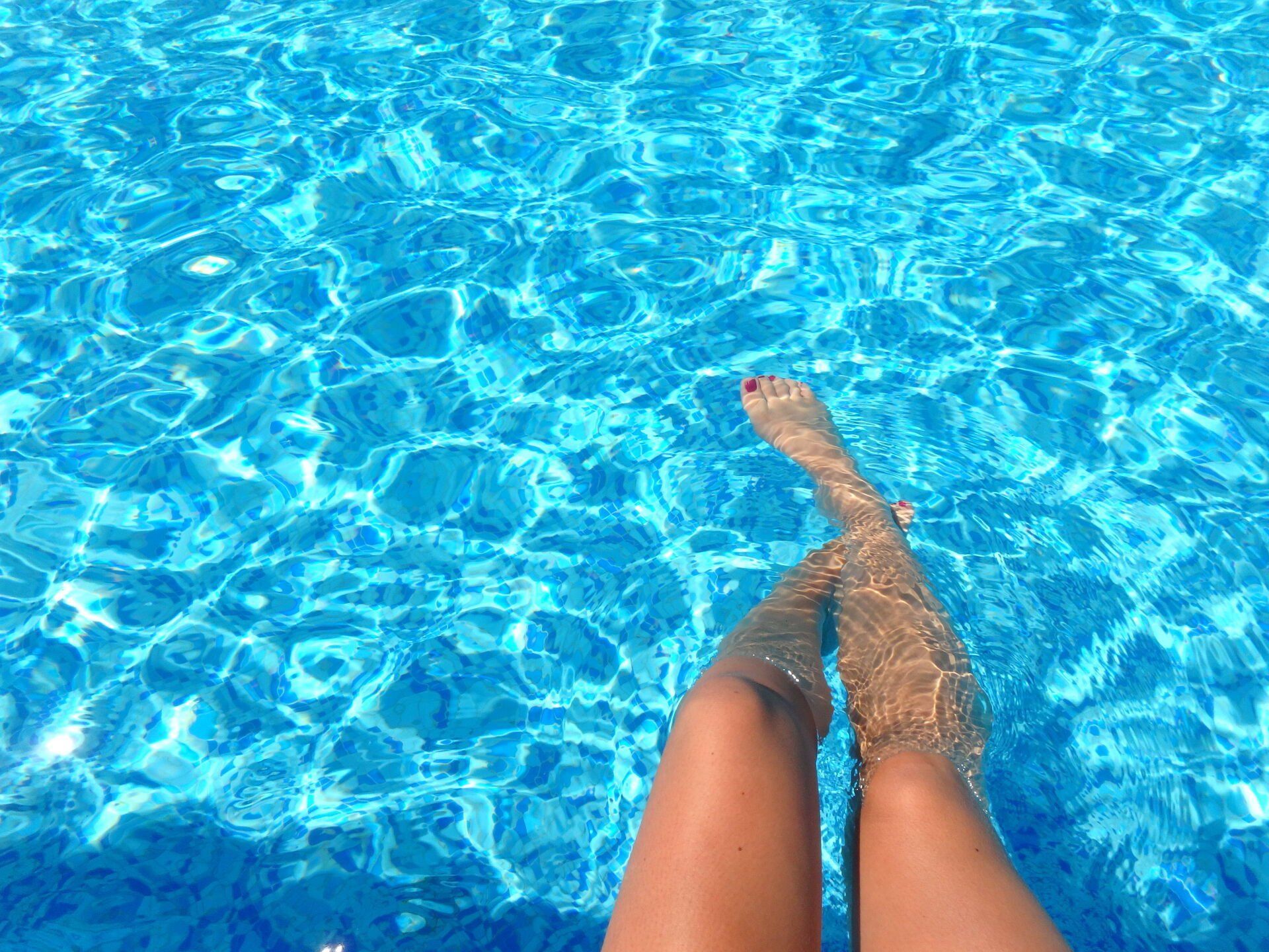 legs and feet in pool on a hot summer day