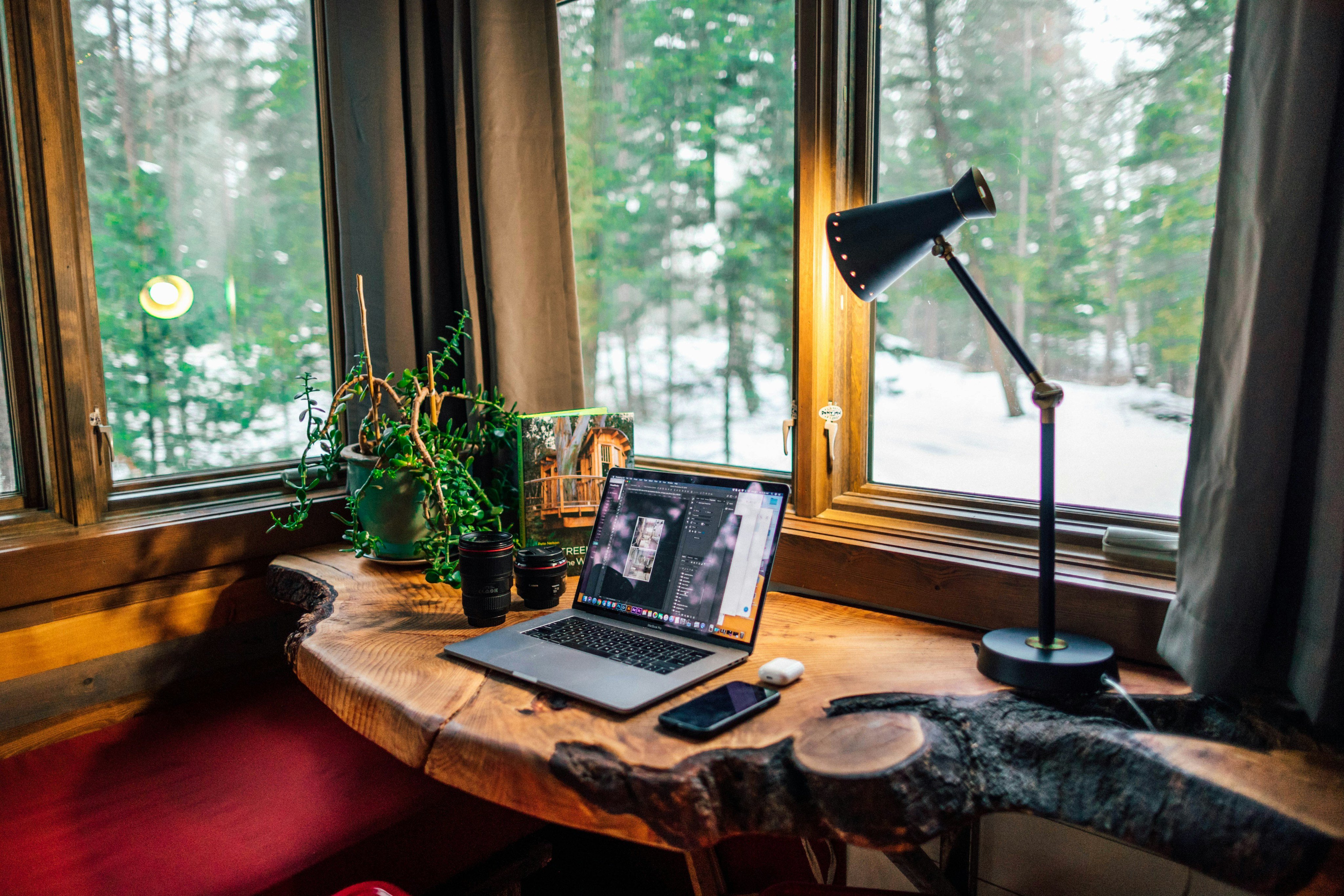 Researching Broken Bow cabin rentals on a laptop inside a cozy pine cabin