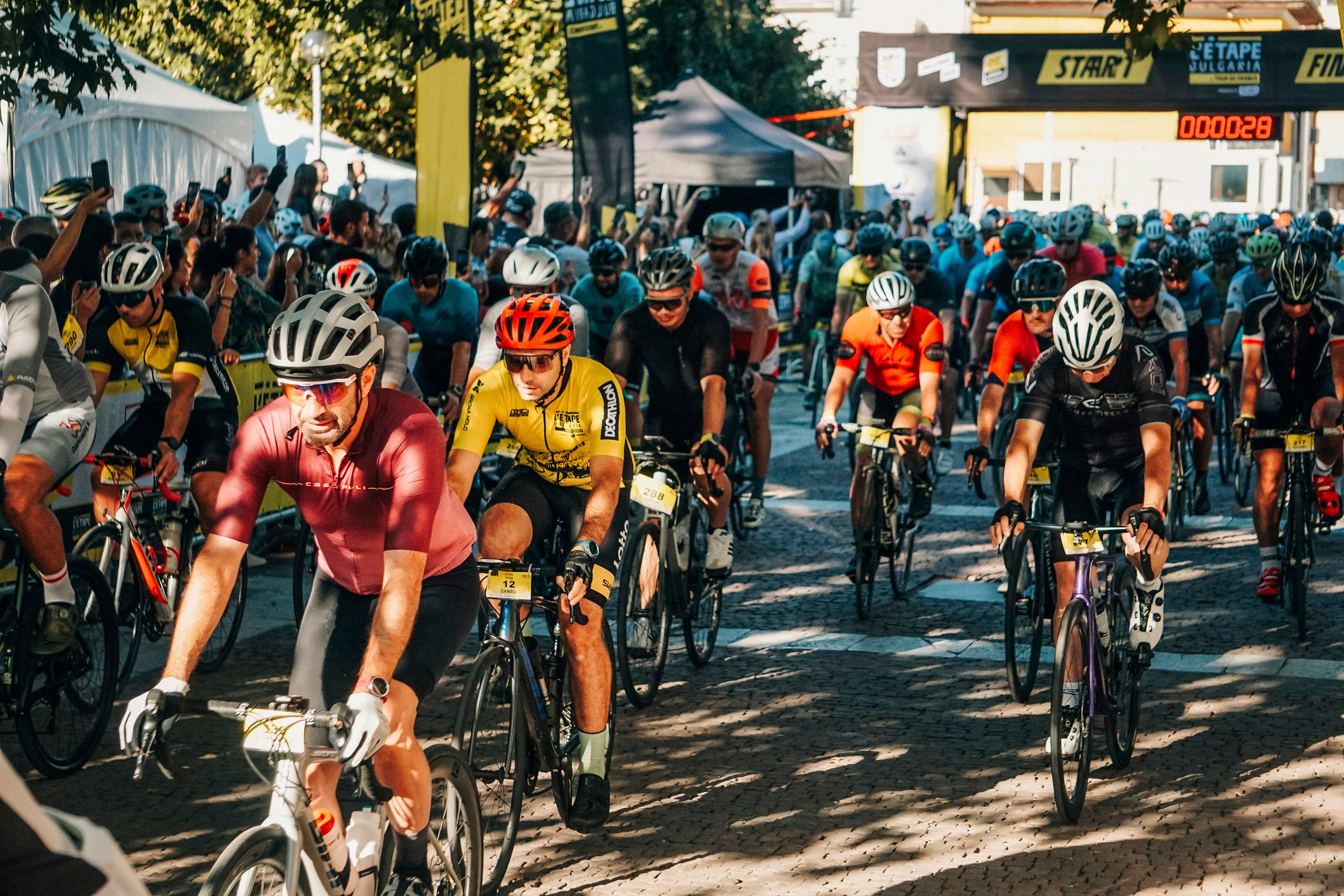 Packed race start with crowds cheering cyclists off the line