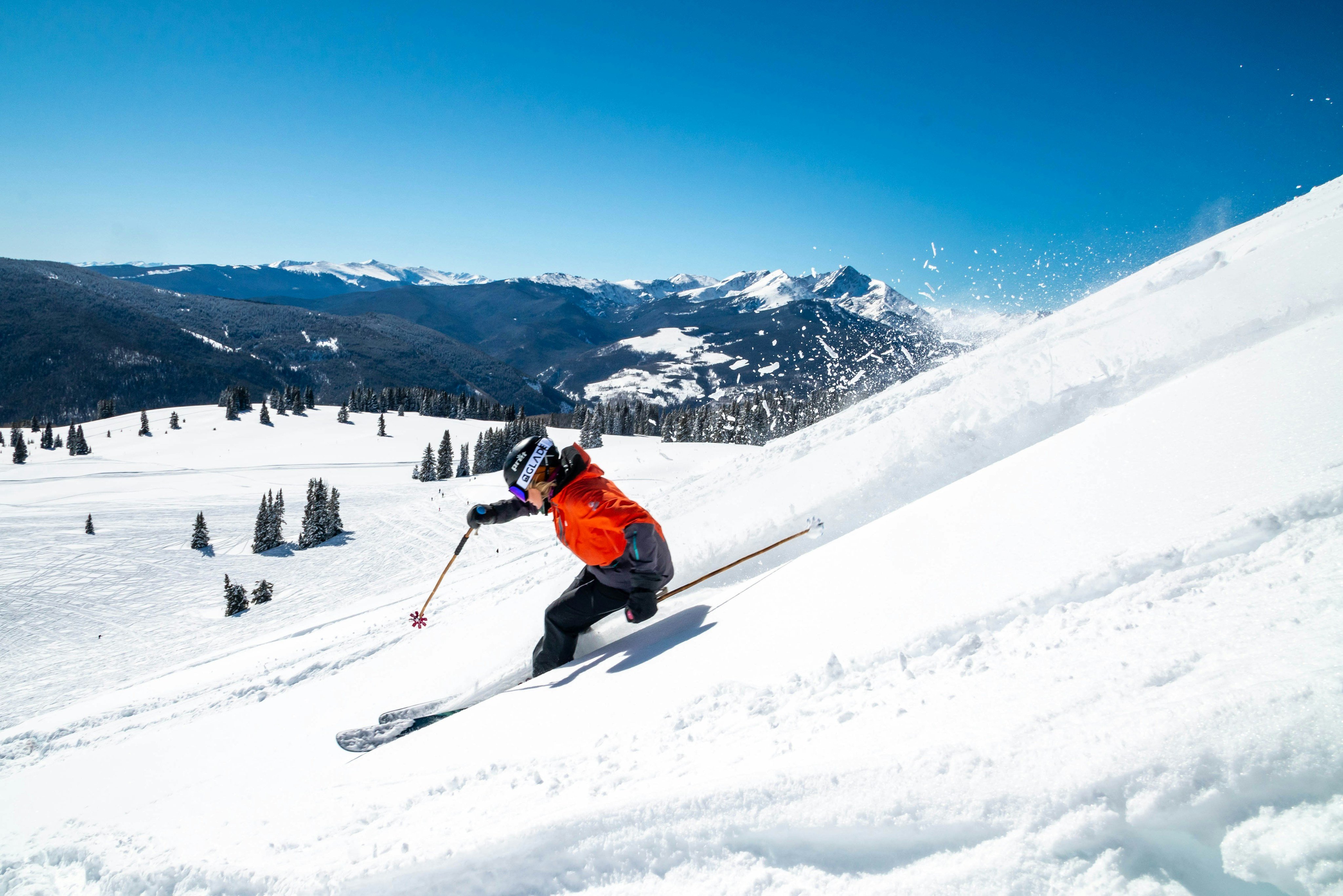 Skier carving powder on a clear winter day in the Bighorn Mountains