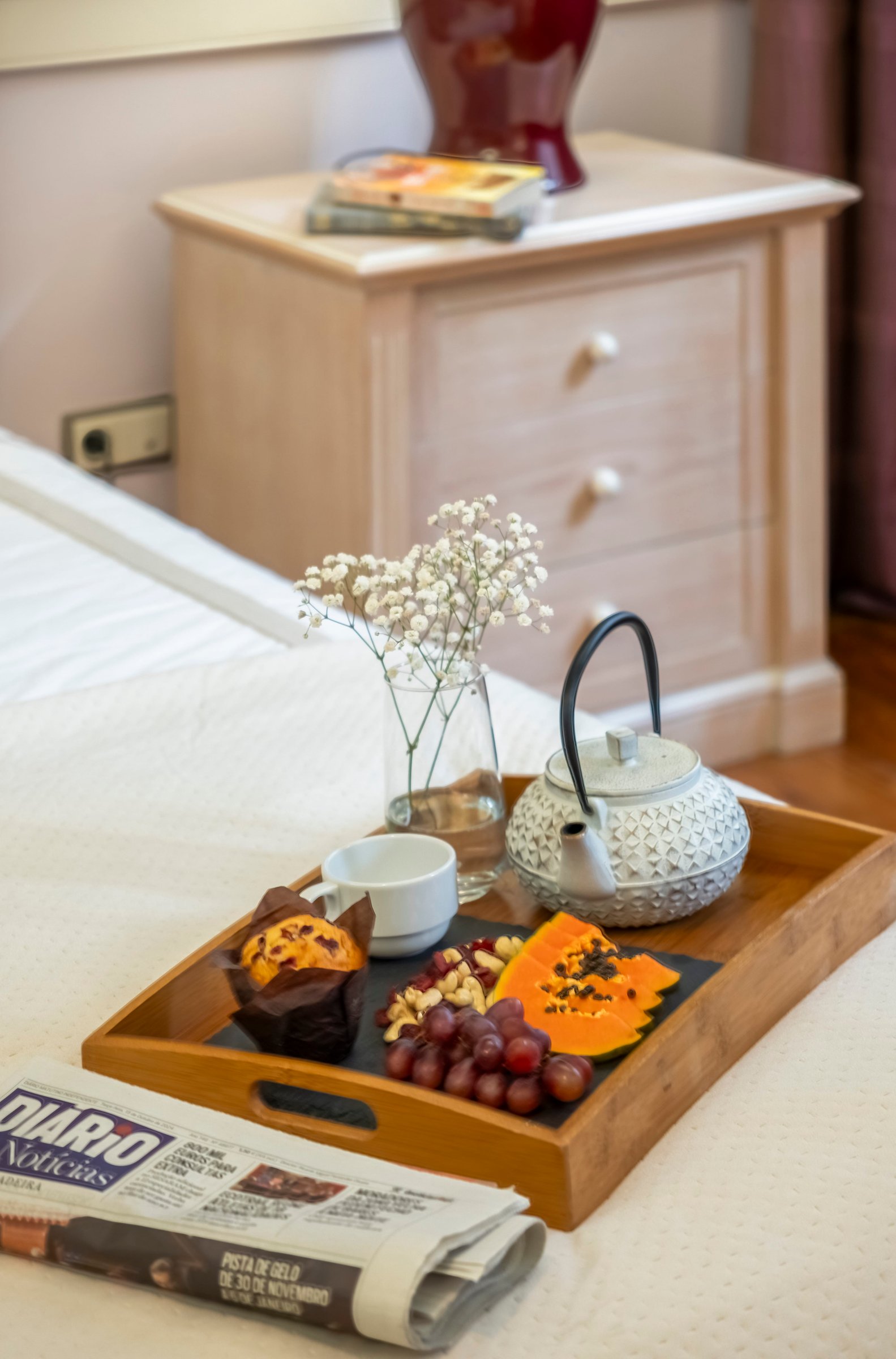 Detail of a bed prepared with white linens and soft lighting, symbolising attention to comfort before check-in.