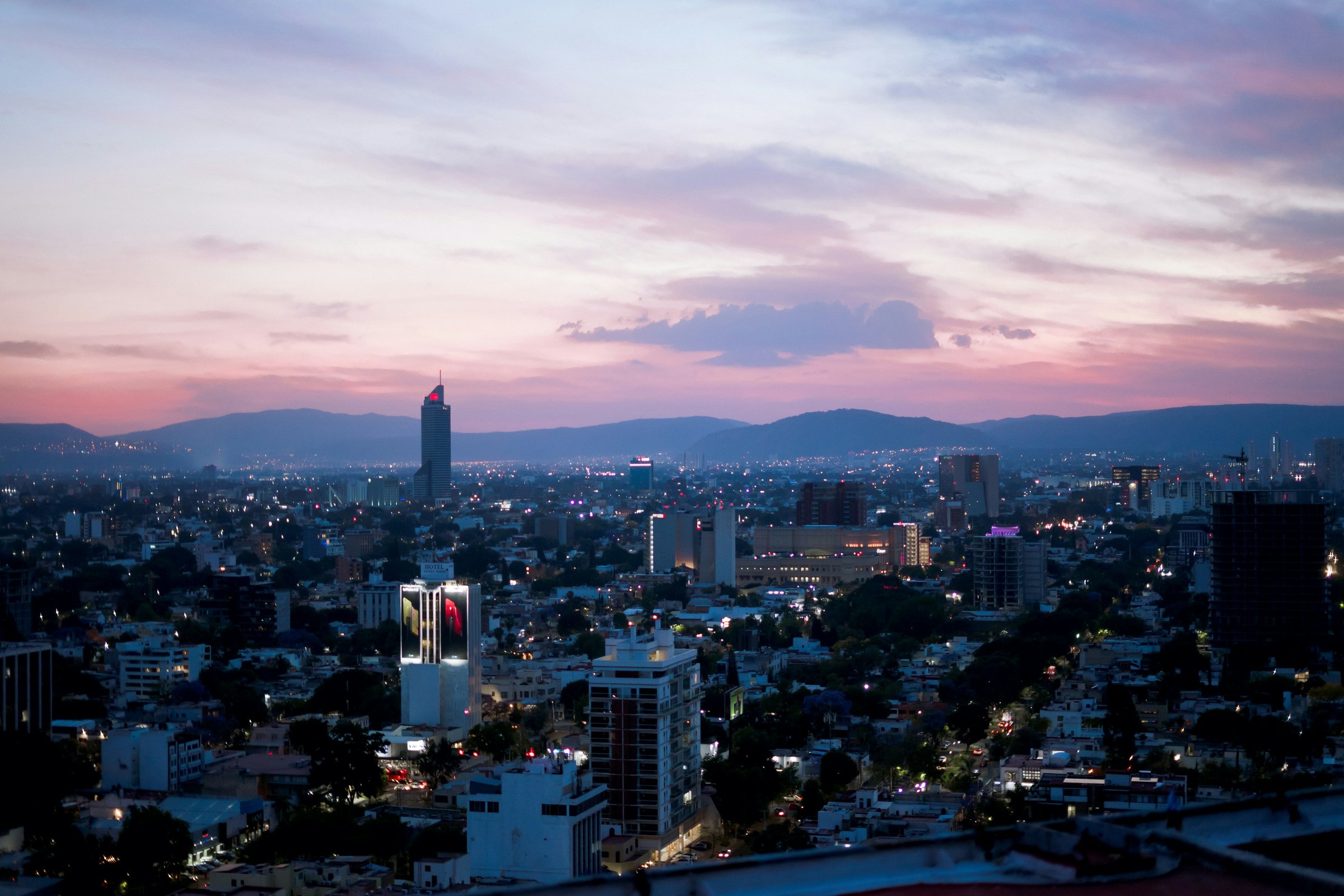 Rooftop terrace of a Guadalajara apartment building looking out over the city at dusk