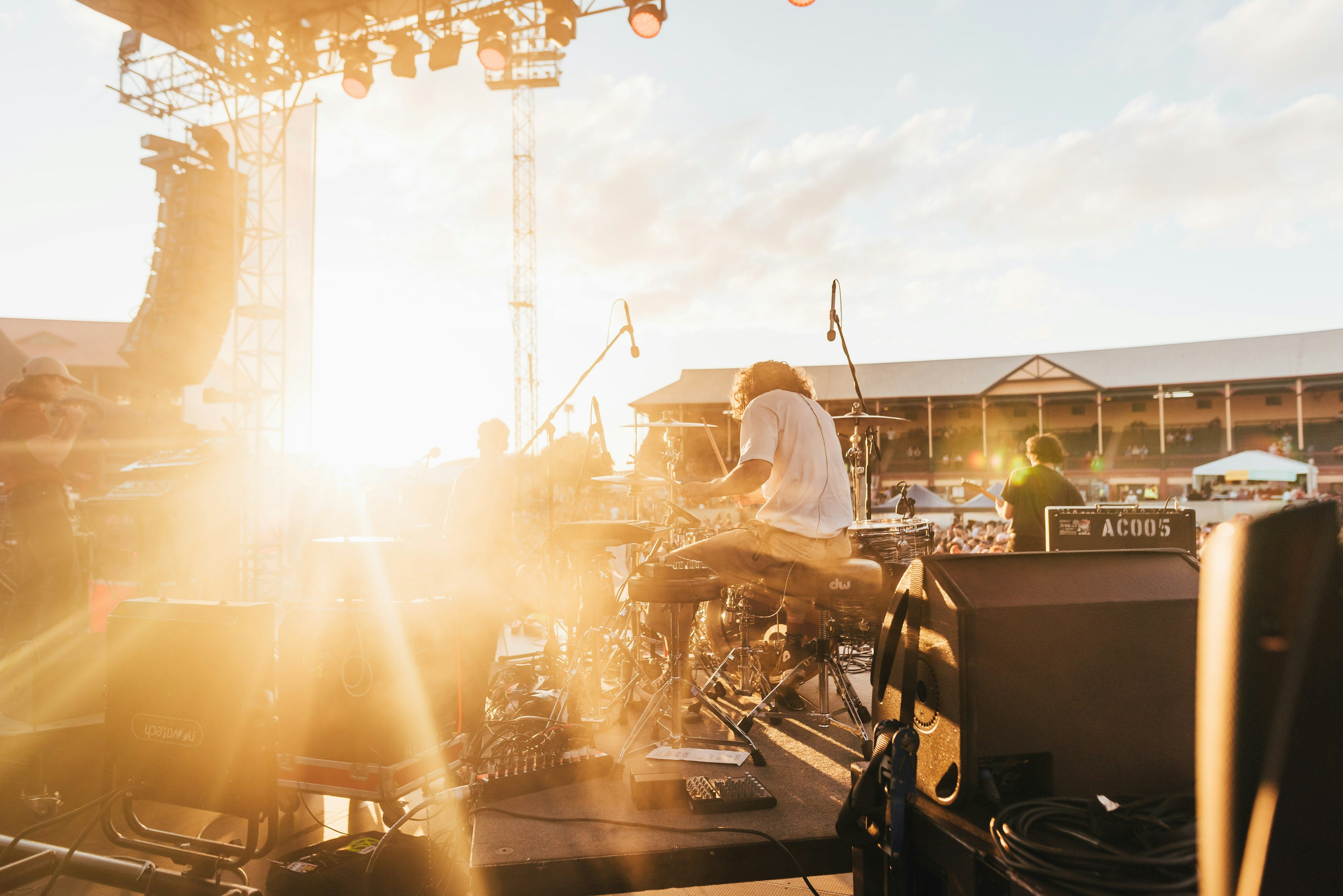 Outdoor festival stage at golden hour, musician performing