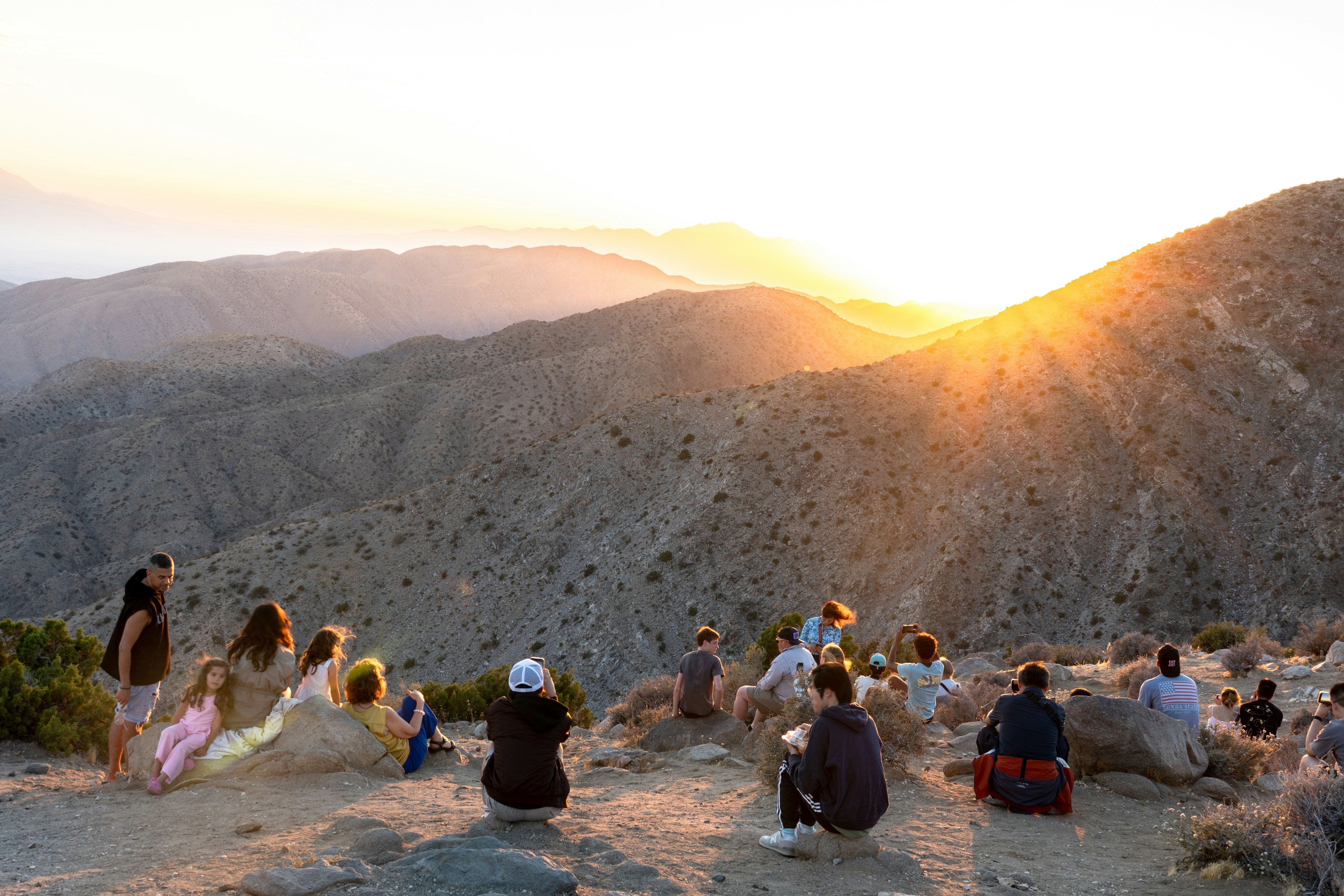 Group watching sunset over desert mountains