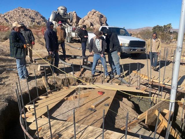 Crew pouring the circular foundation with cement truck on site