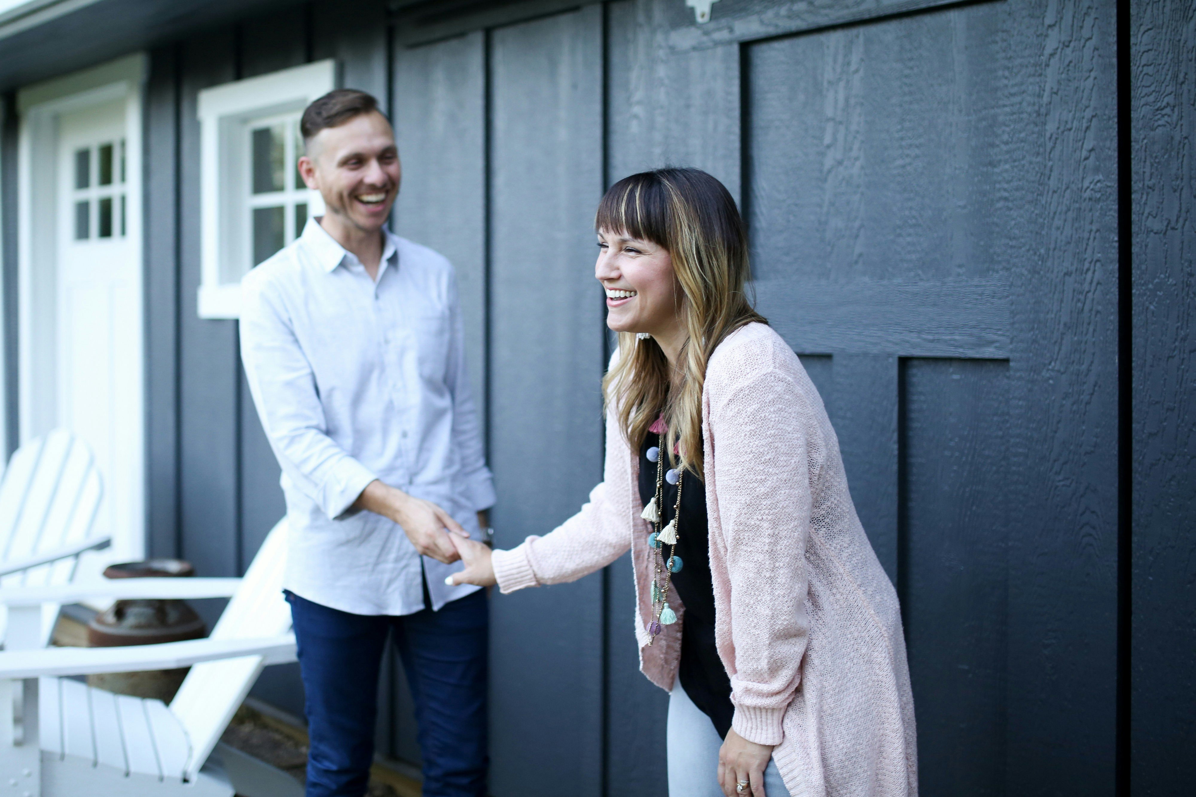 Airbnb host and guest shaking hands at the front door of a vacation rental