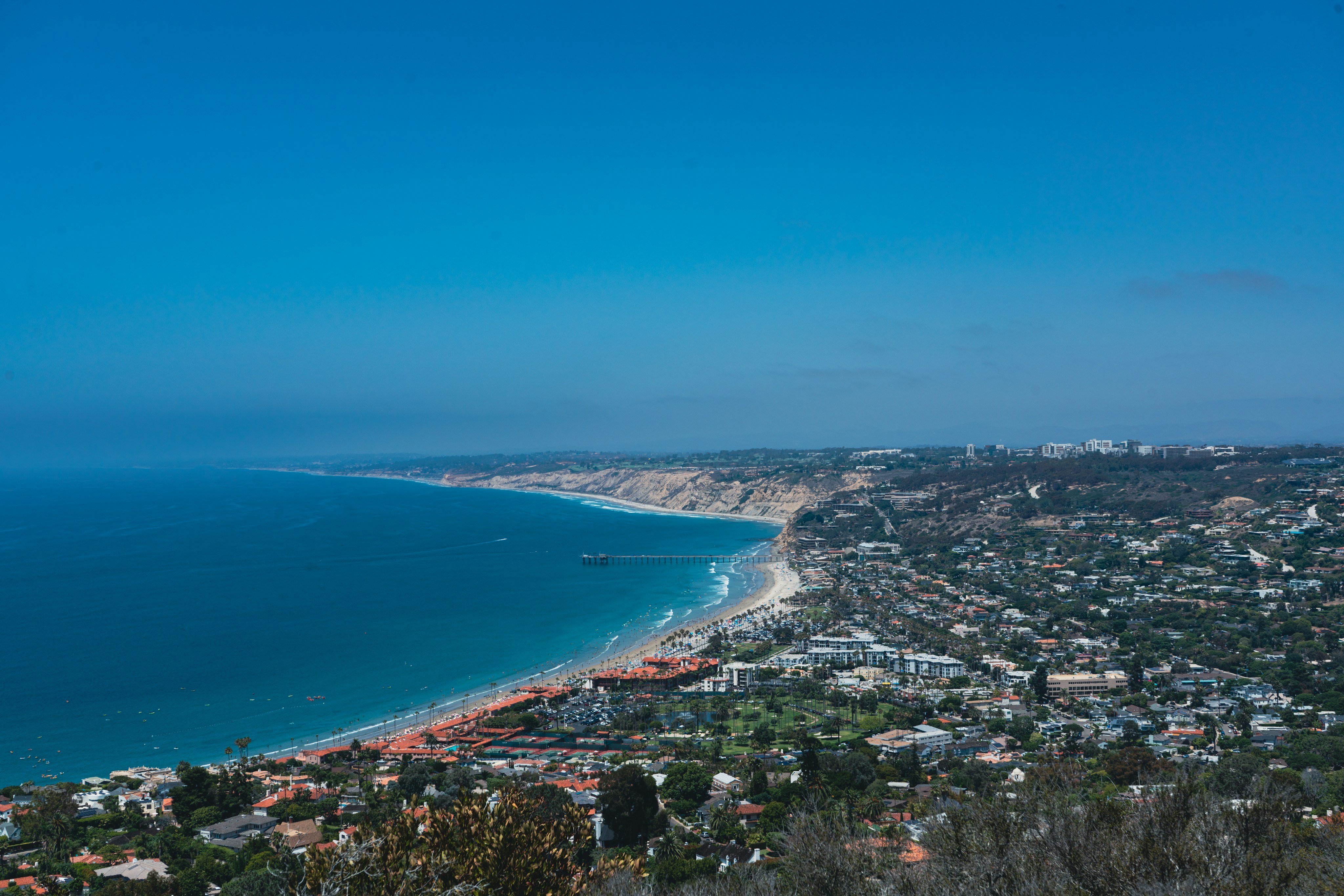 Aerial view of La Jolla Cove San Diego with red cliffs palm trees and blue ocean