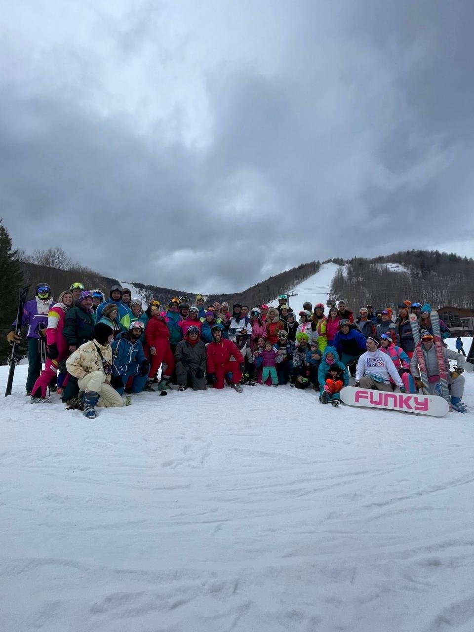 Day-glo crew skiing together at Killington 80s Weekend in matching fluorescent outfits