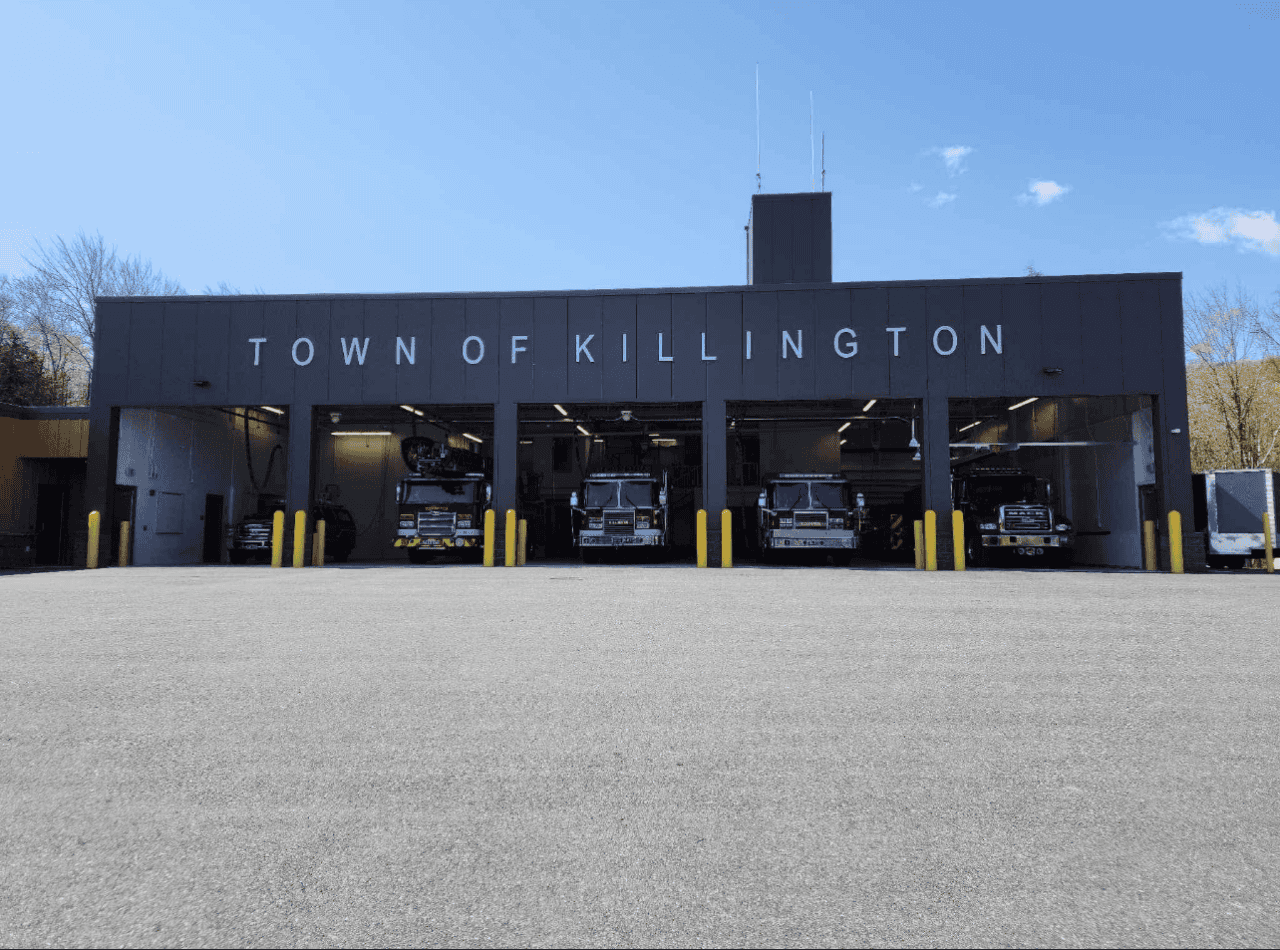 Front of the Killington Fire Department building, with four fire trucks parked in it.