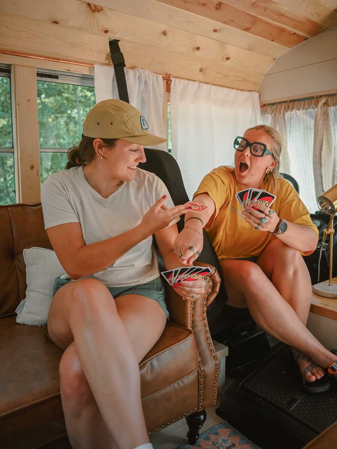 Friends playing Uno in the Skoolie's living area
