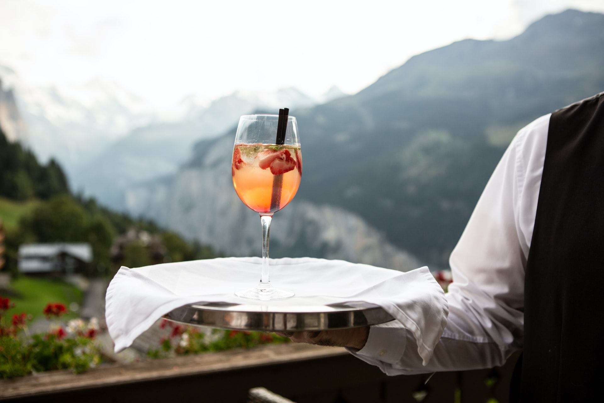 person holding a cocktail on a tray
