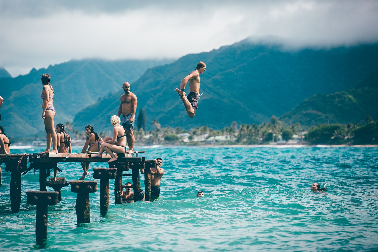 Young folk jumping off the dock of the lake