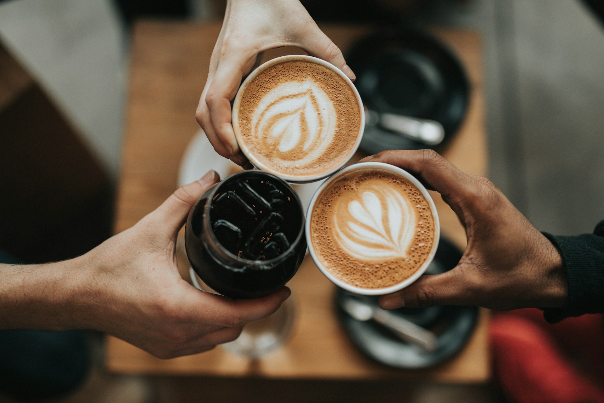 People toasting with lattes and coffee