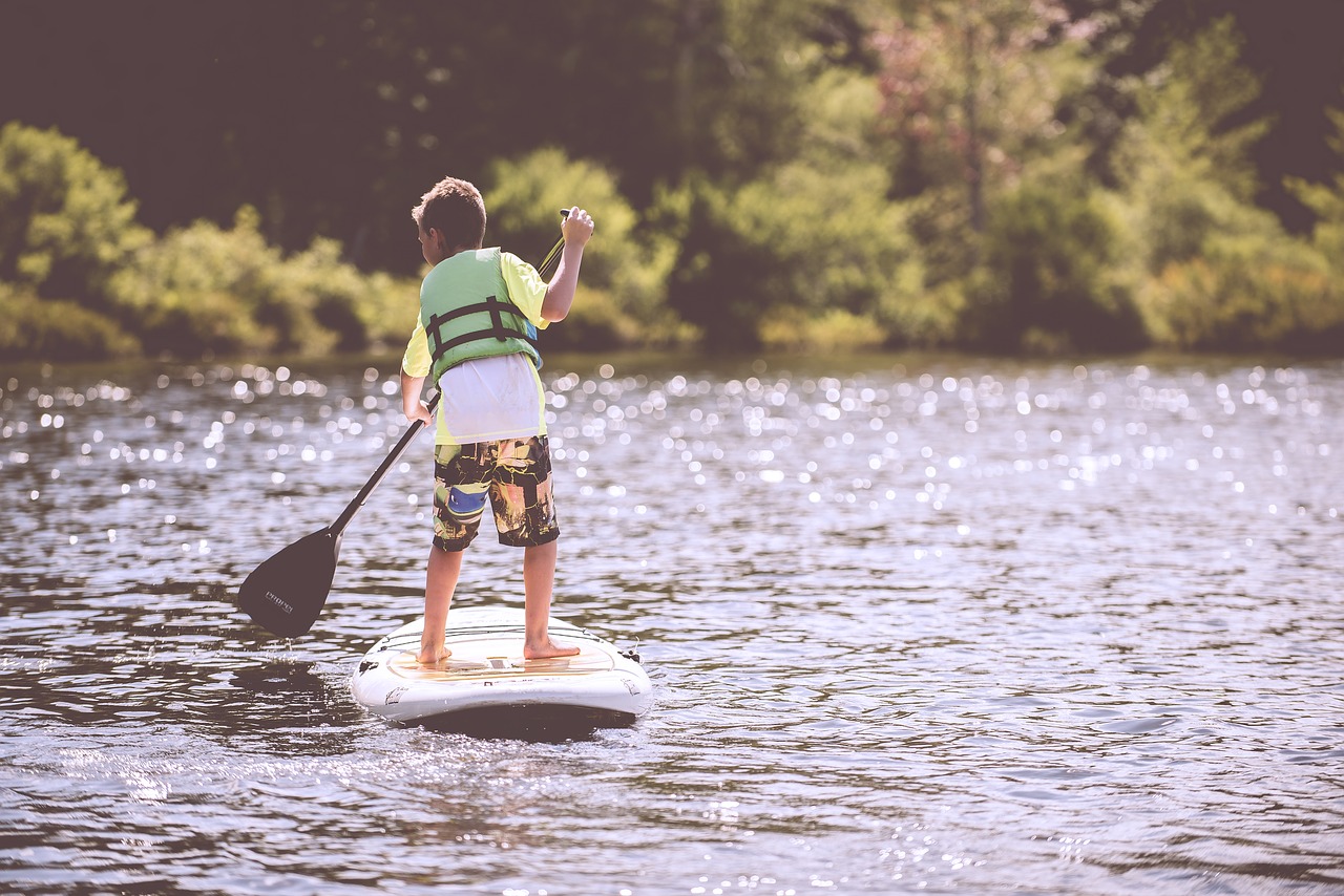 A boy paddleboarding on the lake