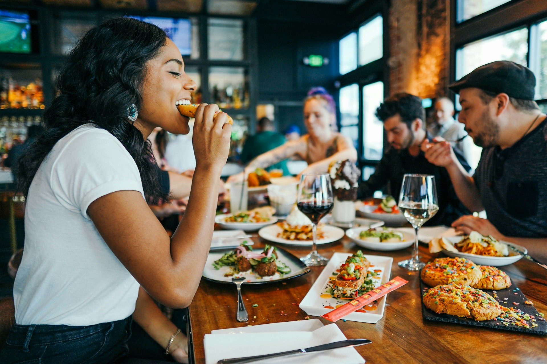 Person eating eggroll at table in restaurant