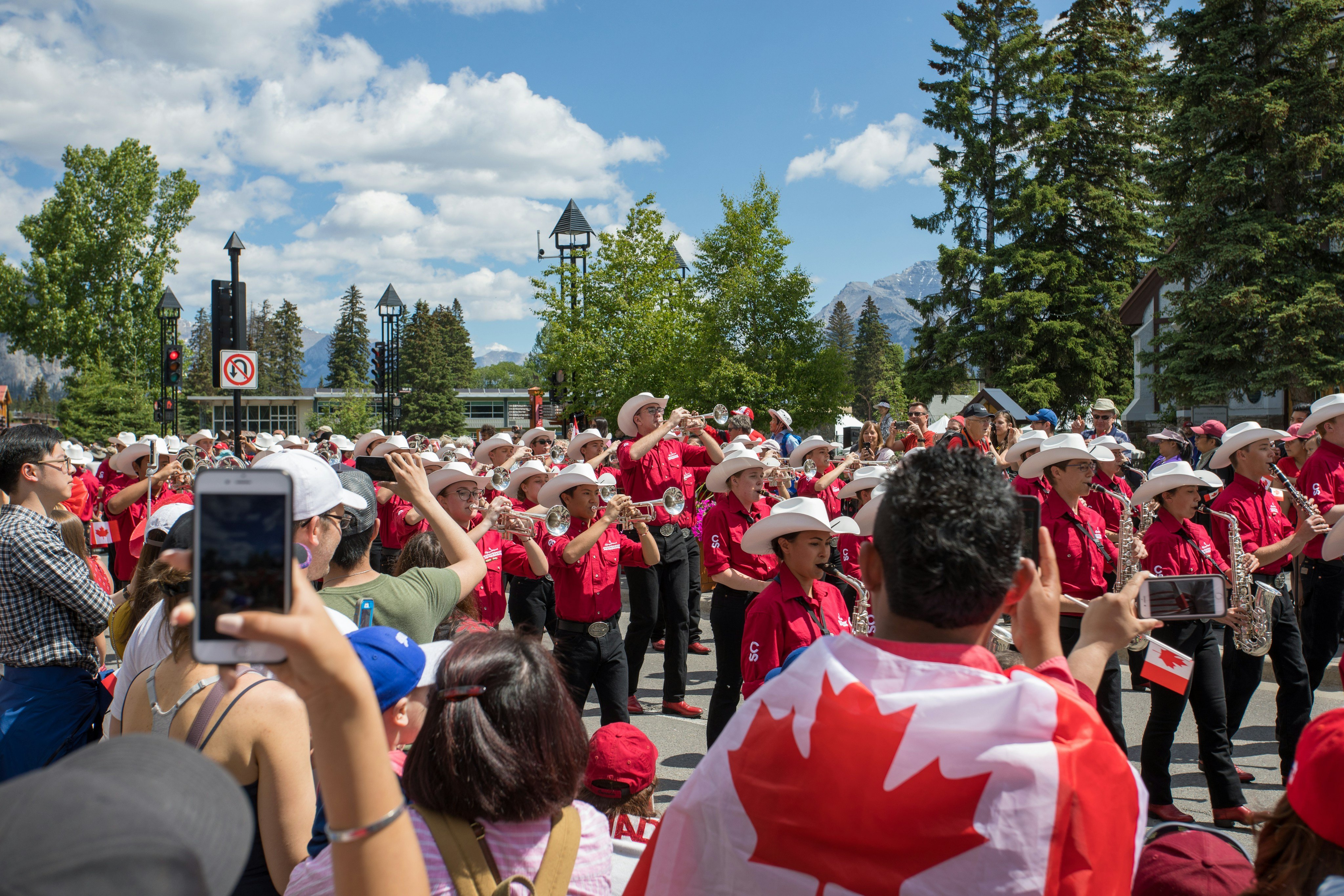 Canada Day parade on Banff Avenue with crowds and Canadian flags