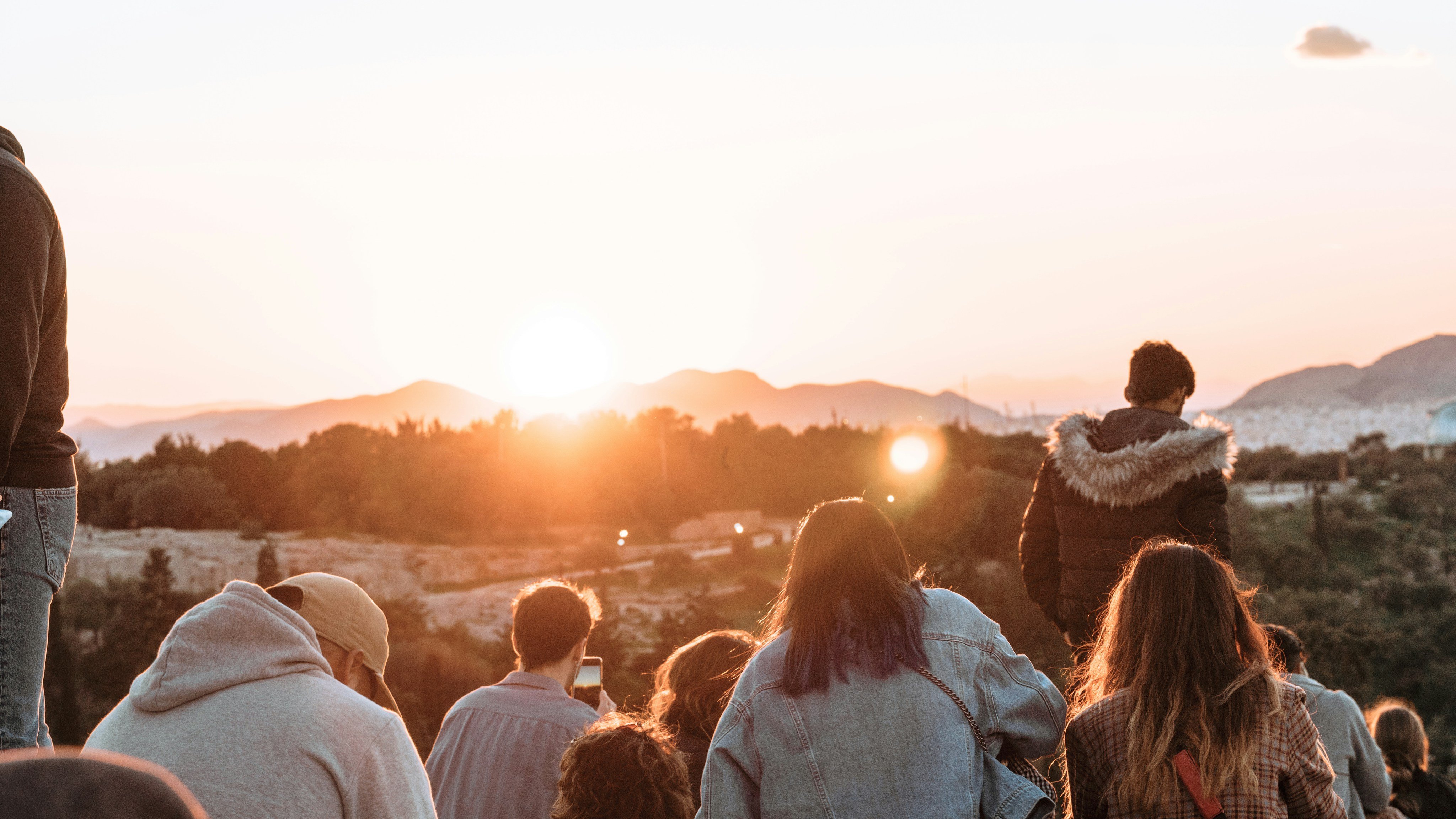 Community gathering watching a mountain sunset