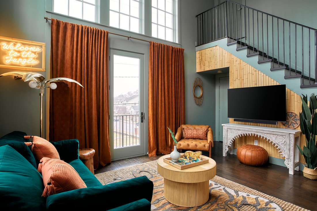 Jungle-themed Airbnb living room in Nashville with layered rugs and tropical accents