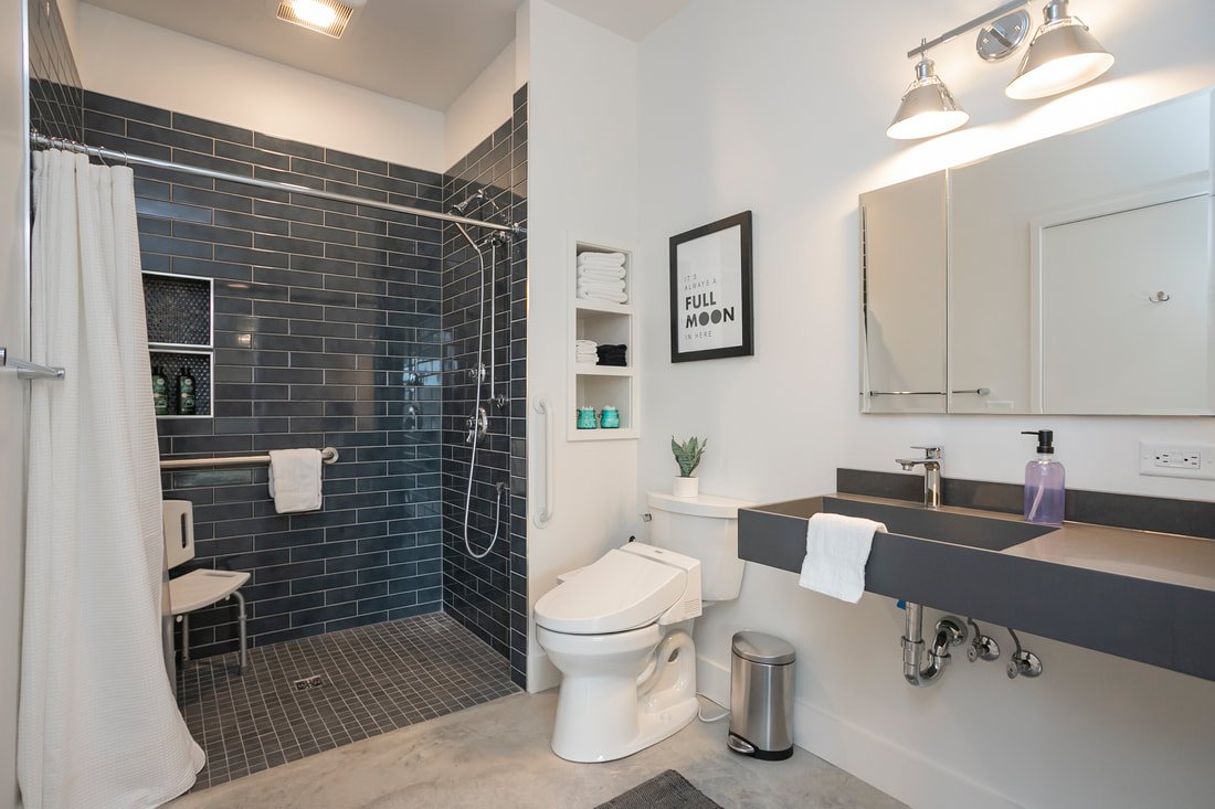 ADA-accessible ensuite bathroom with curbless shower and grab bars