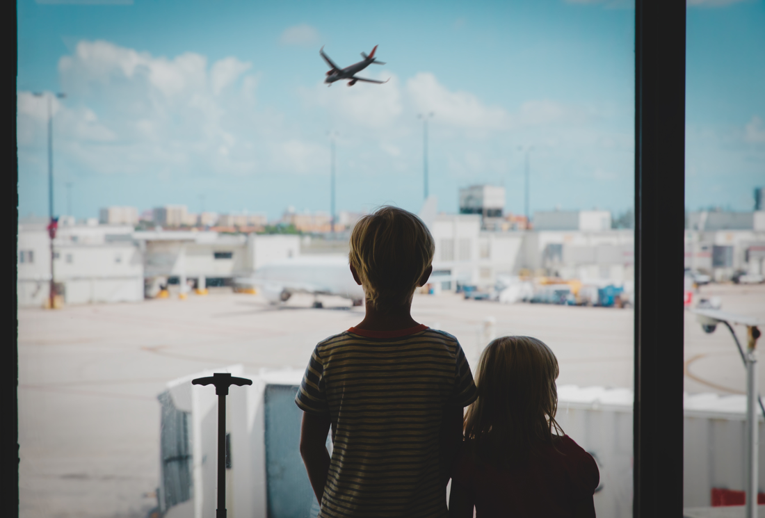 Family traveling through airport with kids