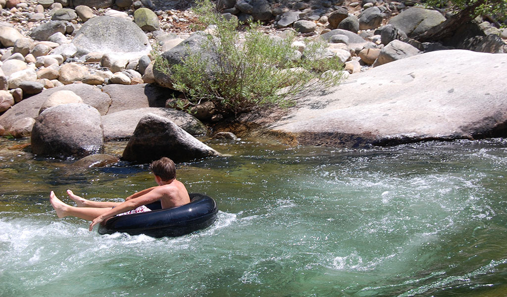 Boy on an inner tube in the river near Swinging Bridge