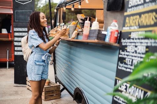 woman ordering from food truck during festival