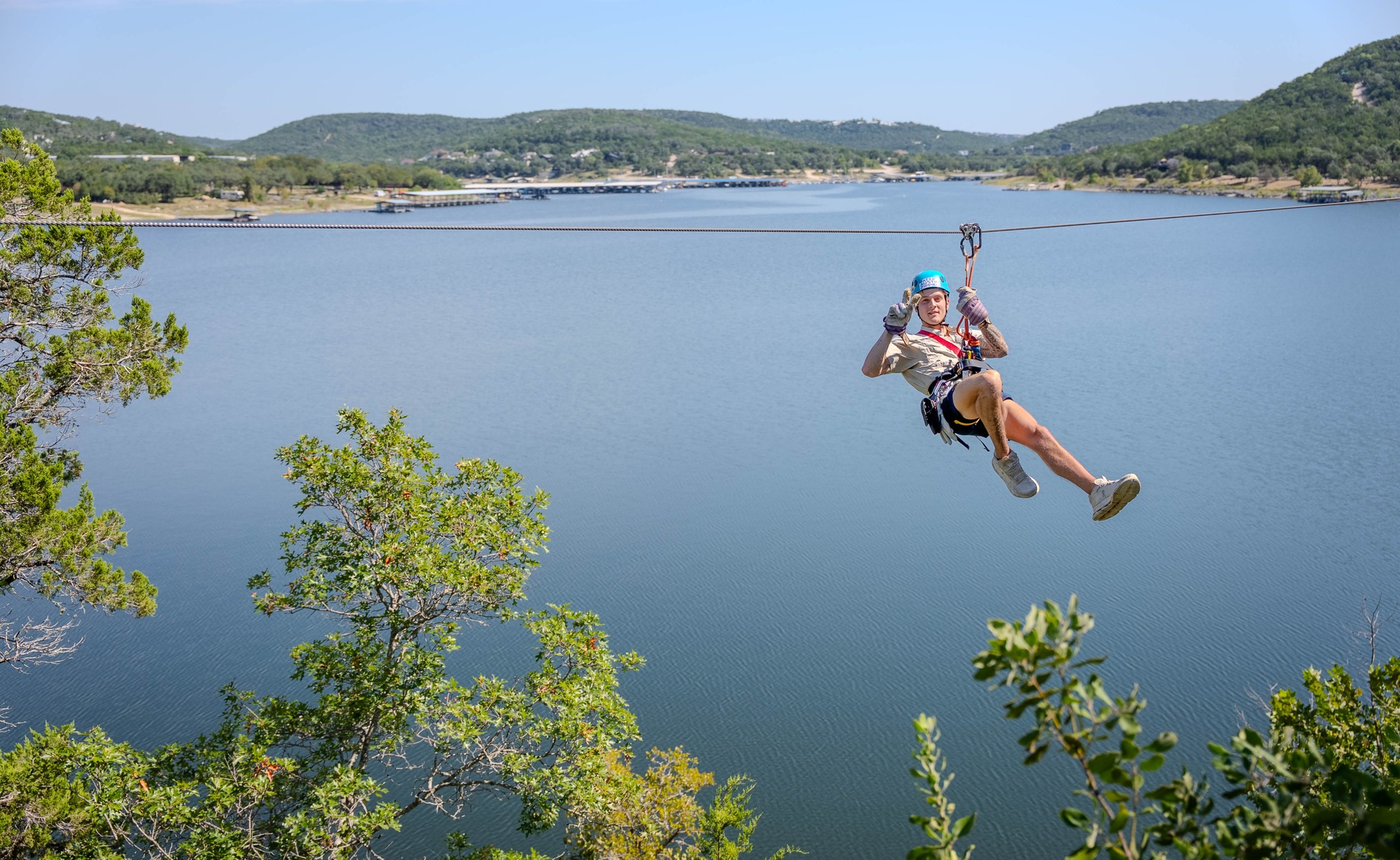 A guide ziplining over Lake Travis.